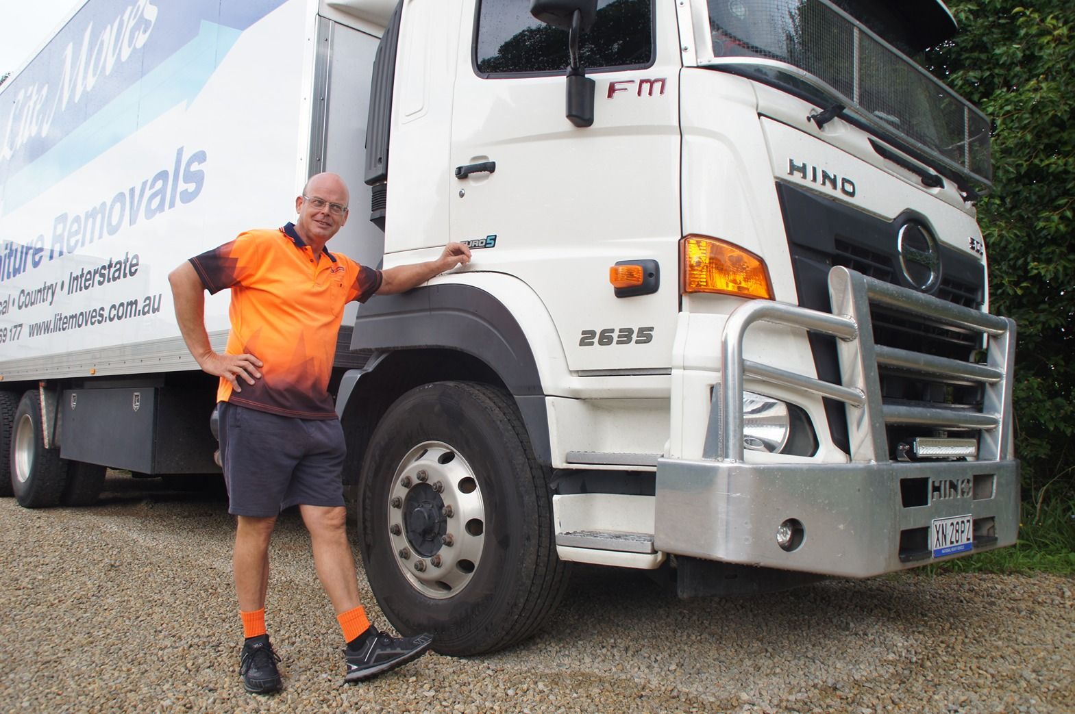 A Moving Truck Is Parked in Front of A House — Lite Moves Furniture Removals In Coffs Harbour, NSW