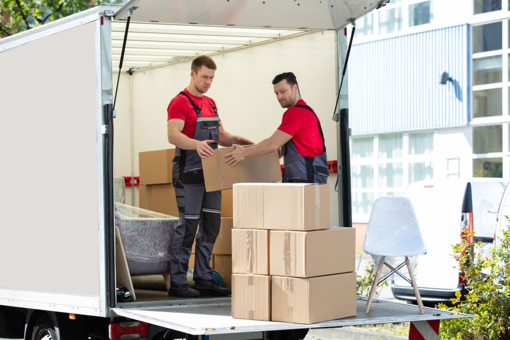 Two Men Are Loading Boxes Into a Moving Truck — Lite Moves Furniture Removals In Sydney, NSW