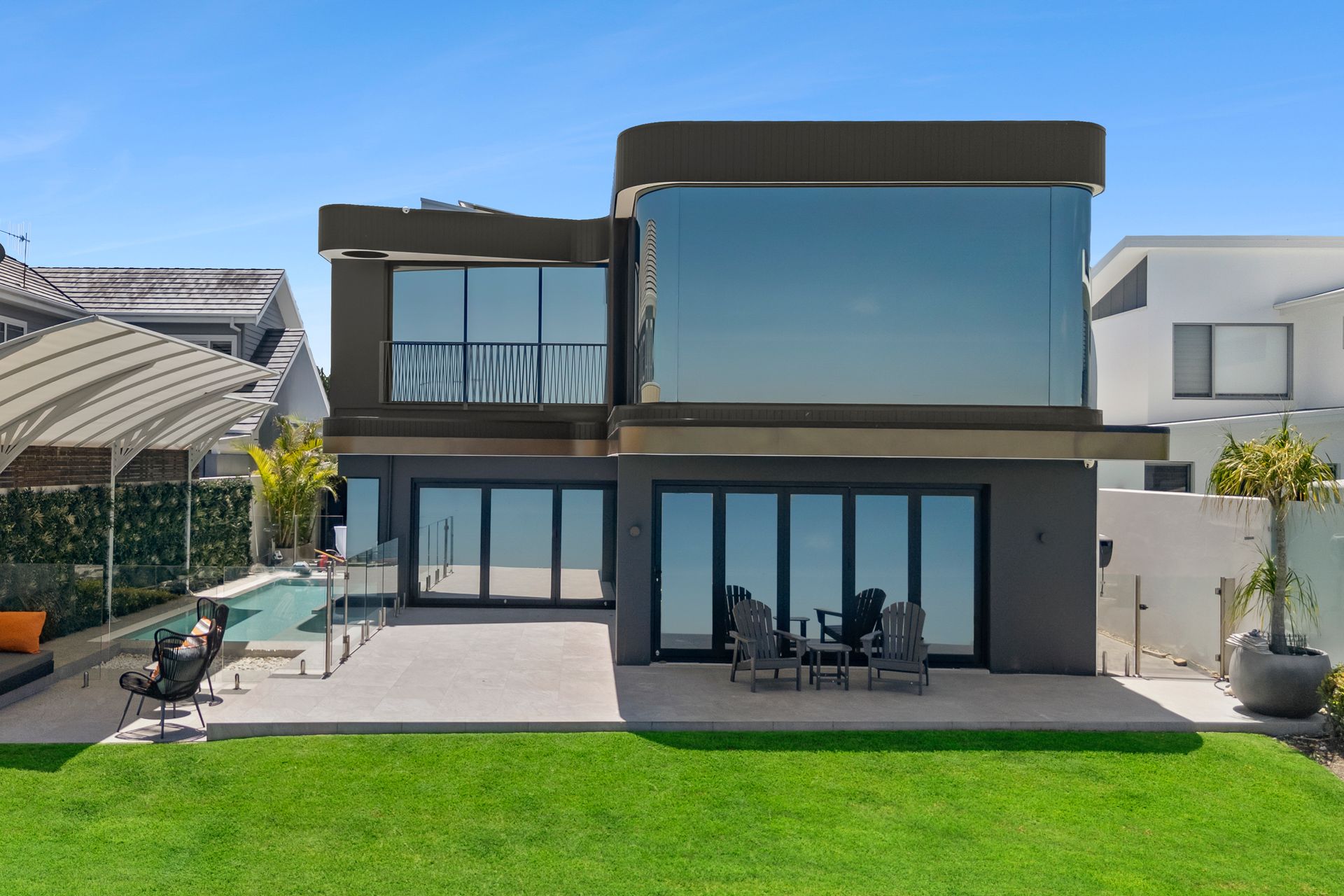 Modern two-story house with large windows and a pool, viewed from the backyard. Gray exterior, sunny day. — PK4 Projects in Port Macquarie, NSW
