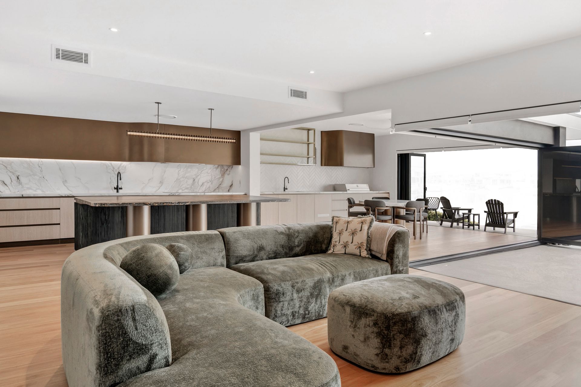 Modern living room with a fluffy sectional sofa, open to a kitchen and dining area — PK4 Projects in Port Macquarie, NSW