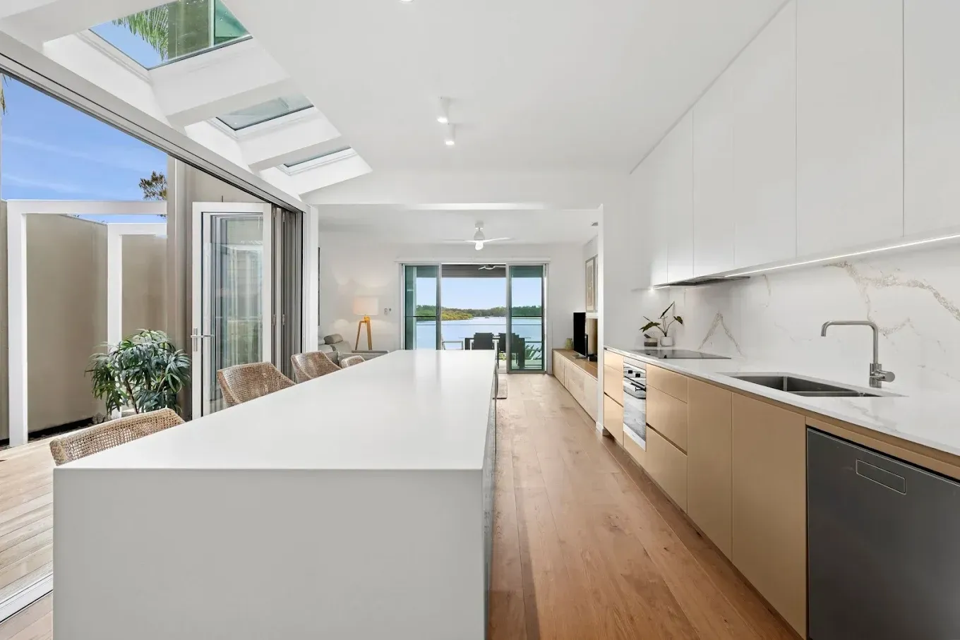 Modern kitchen with white island, light wood cabinets, and water view  — PK4 Projects in Port Macquarie, NSW