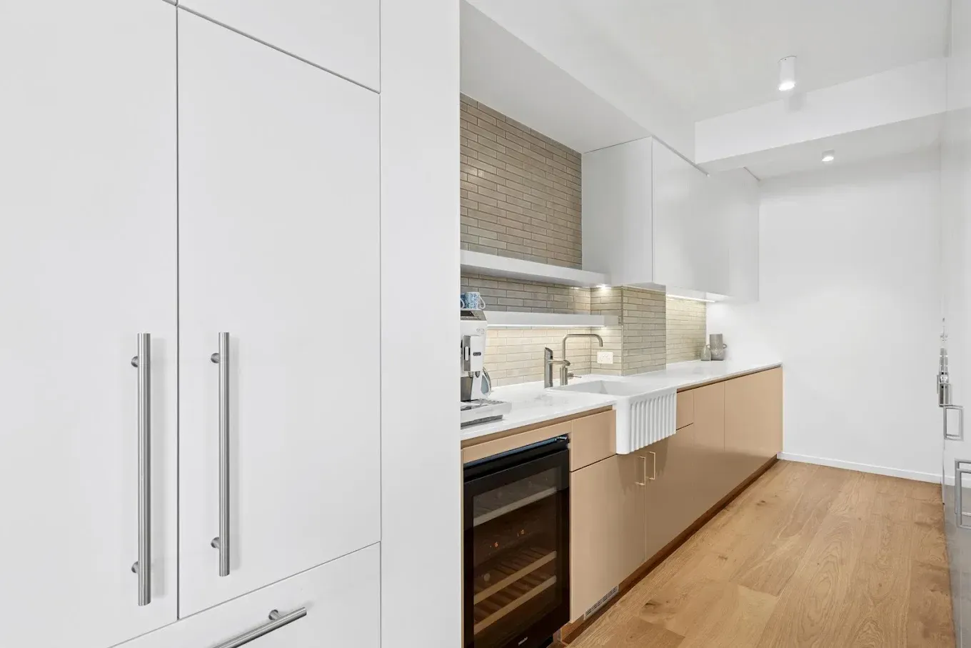 Modern kitchen with white and beige cabinets, stainless steel hardware, and a wine fridge  — PK4 Projects in Port Macquarie, NSW