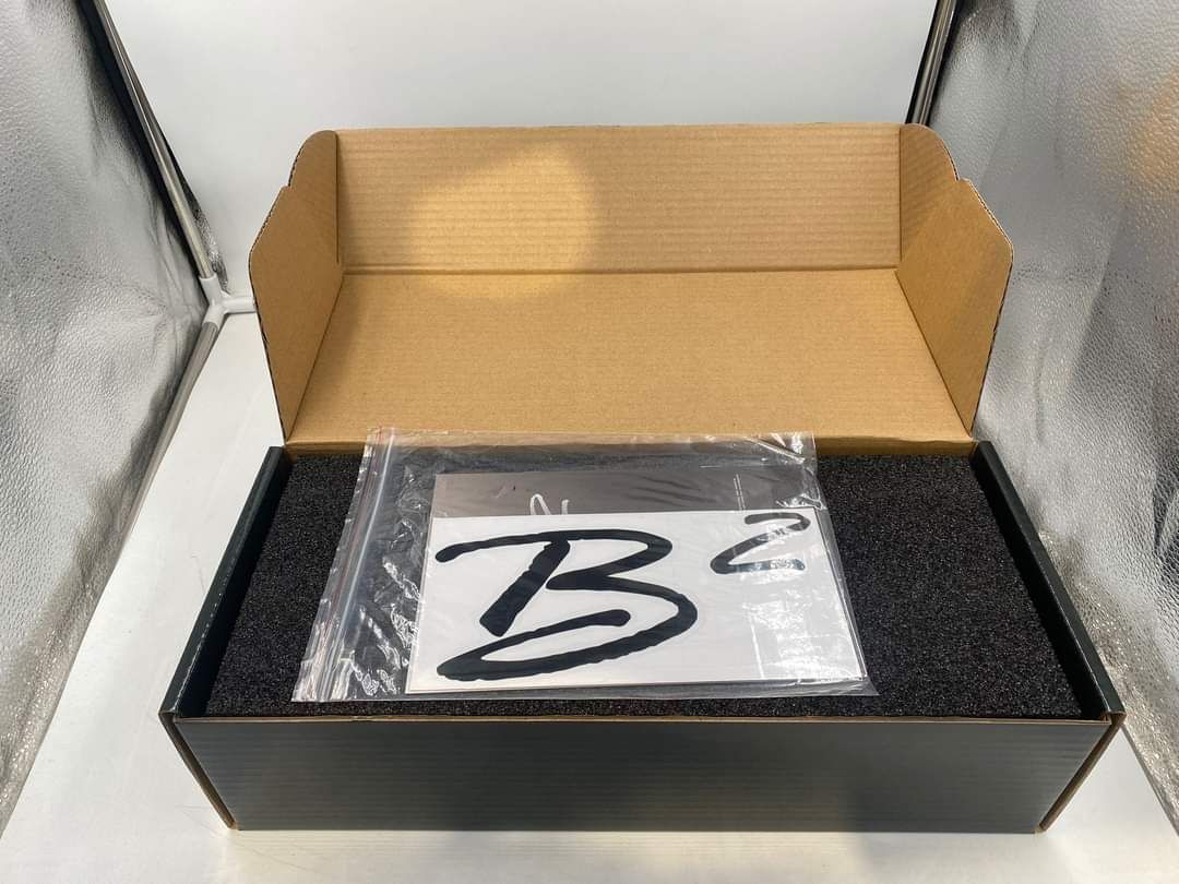 Een kartonnen doos met een plastic zak met de letter b erop.