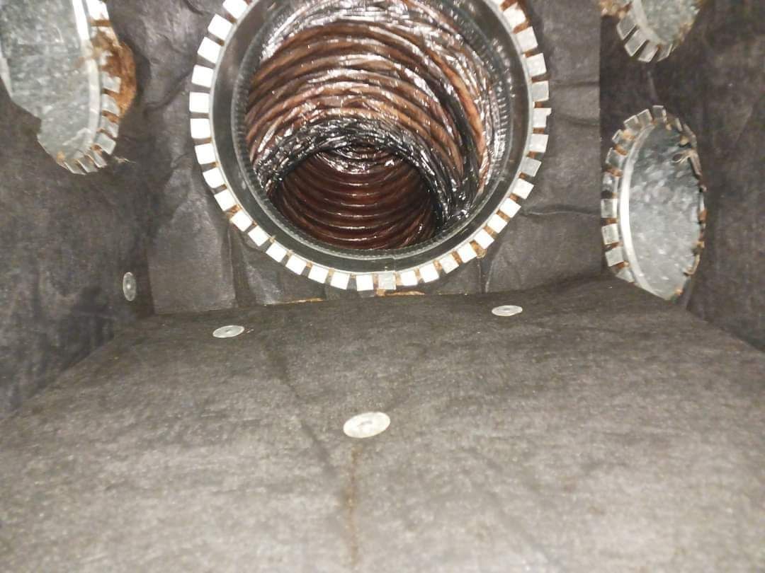 Large circular tunnel lined with stone or metal, with several round side openings in a gray interior.