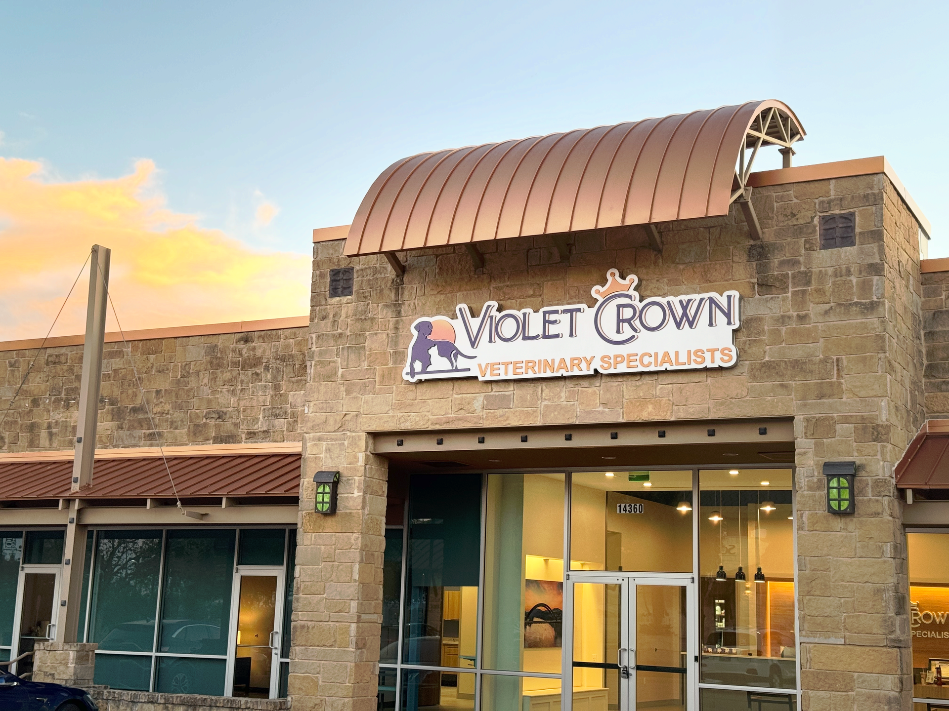 Motel Town storefront with stone facade and curved awning at sunset