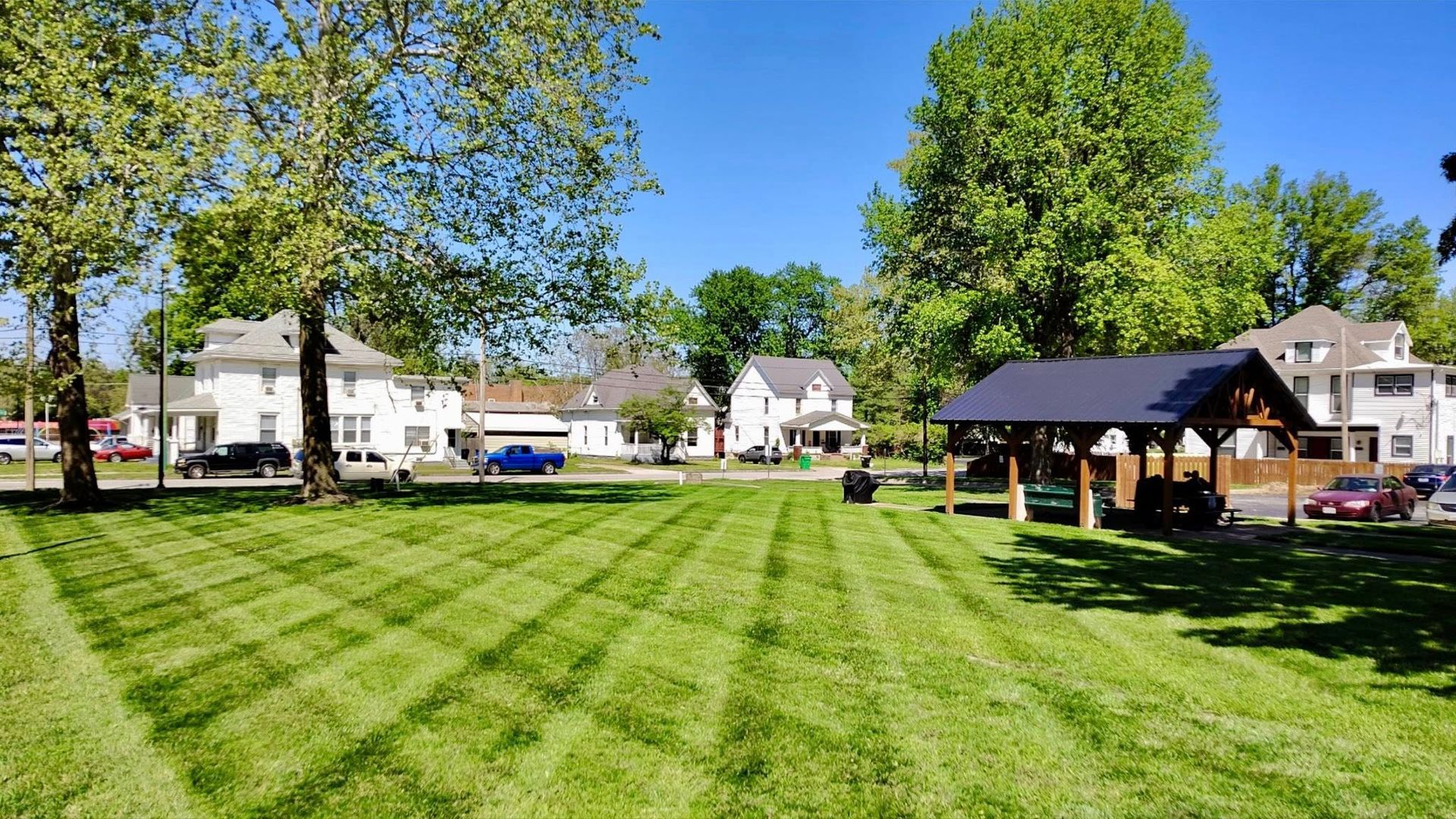A large building with a lot of windows is surrounded by grass and trees.