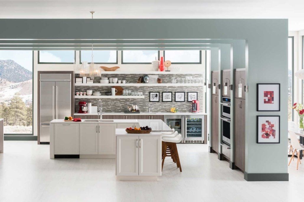 Modern white kitchen with island, open shelves, stainless appliances, and red pendant lights