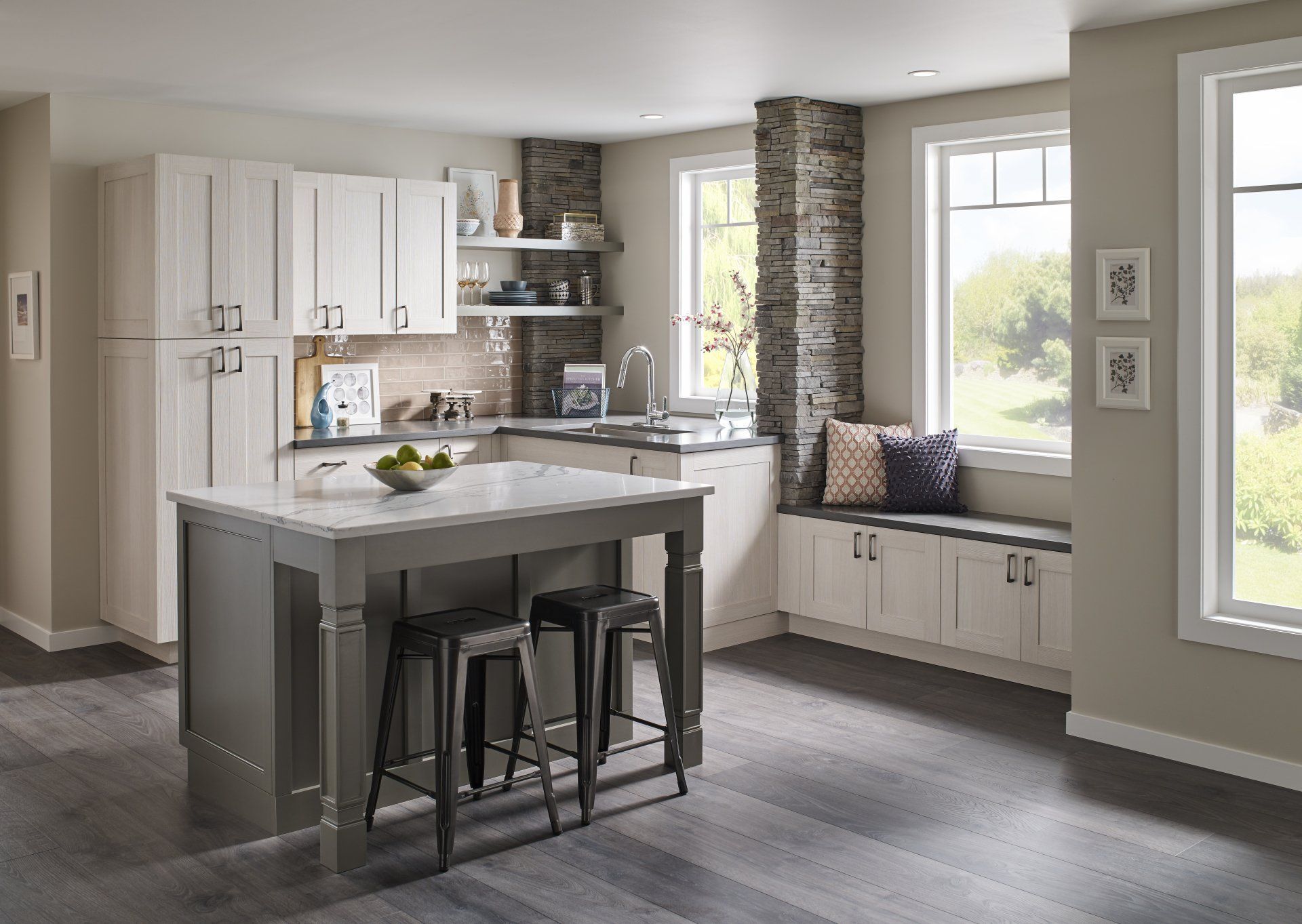 Modern kitchen with gray island, white cabinets, and large windows overlooking a bright view
