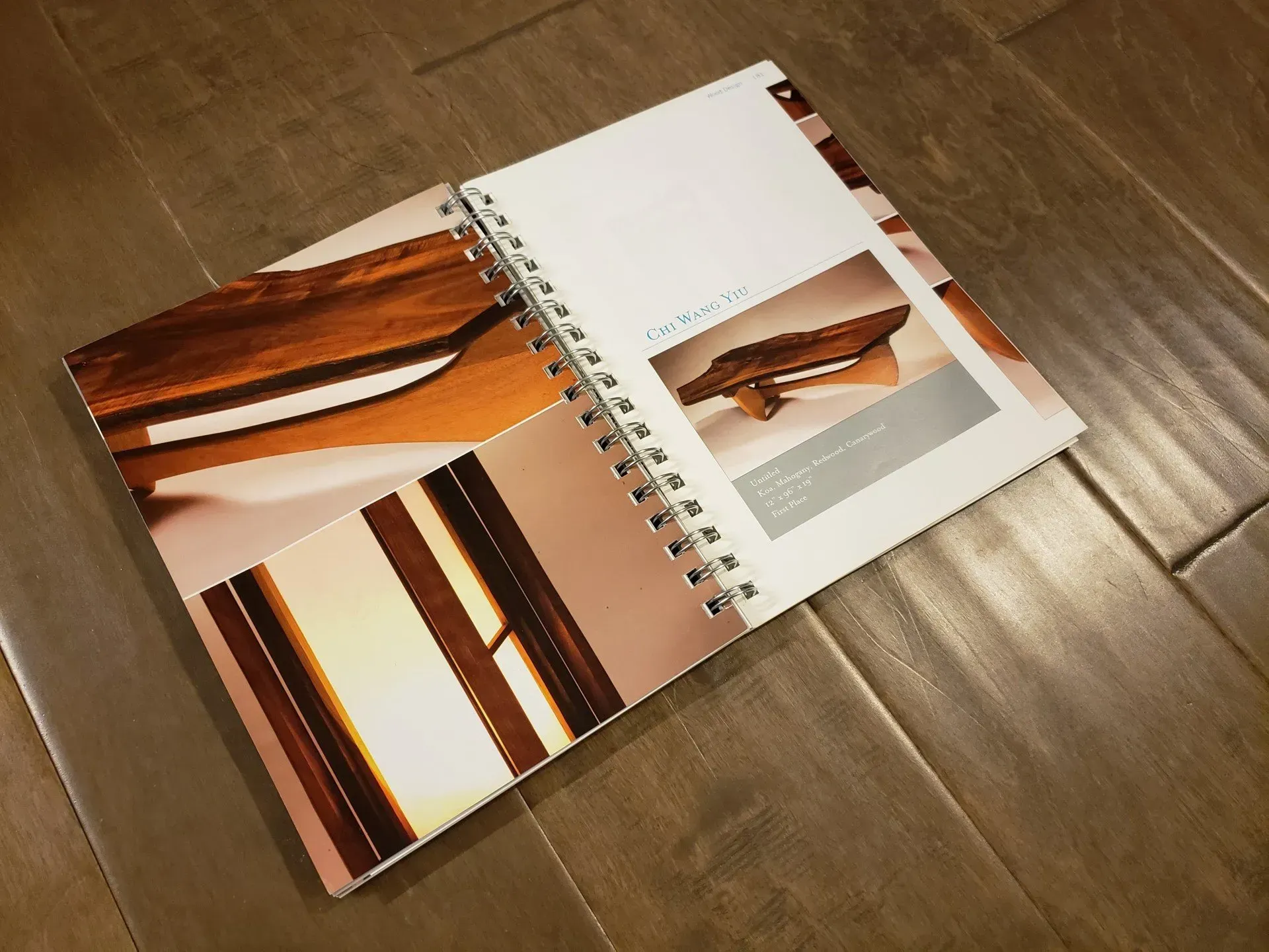 Open spiral notebook on wooden floor with abstract brown and orange design pages