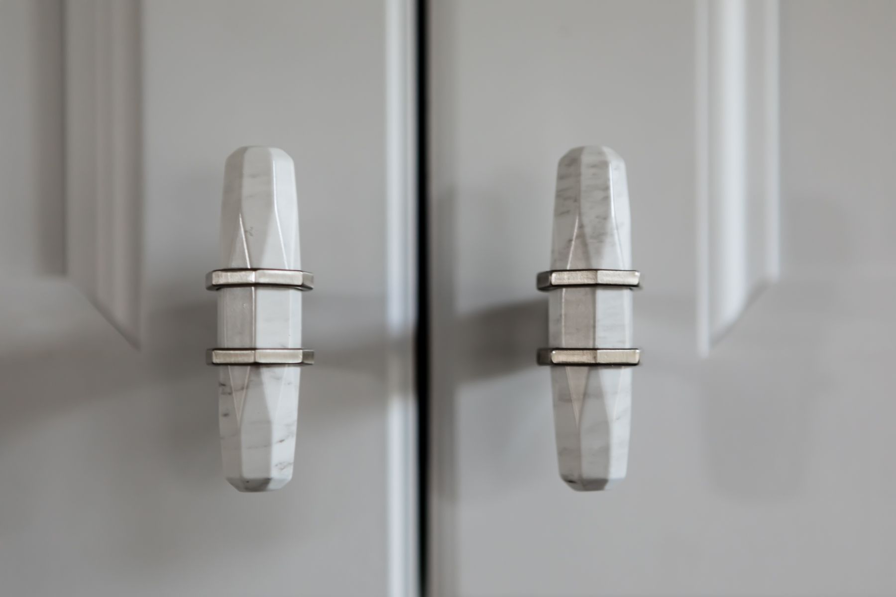 White cabinet doors with silver handles against a light gray background