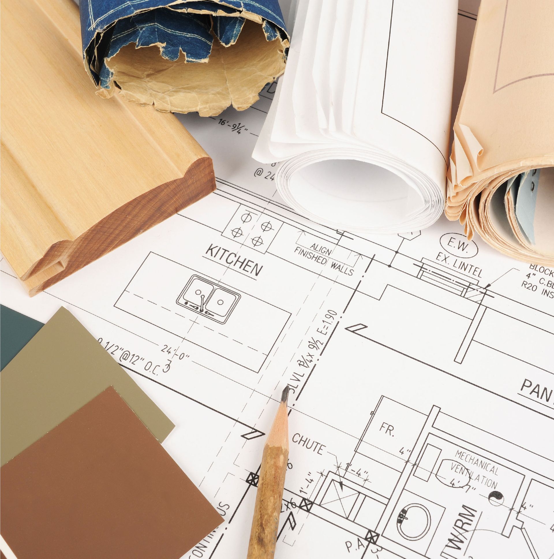 Rolled and torn wallpaper samples with kitchen floor plans and a pencil on a table