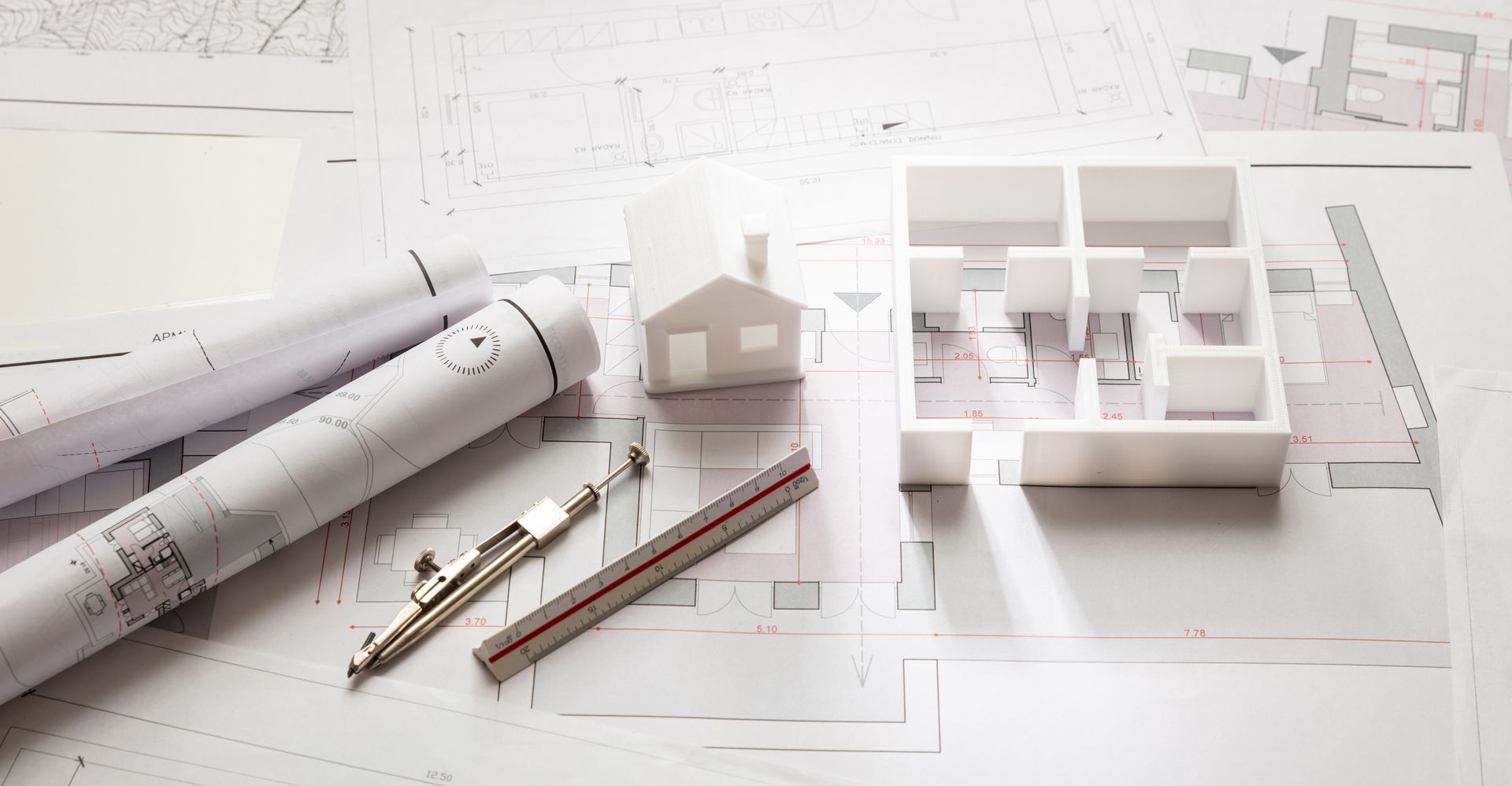 A model of a house is sitting on top of a blueprint.