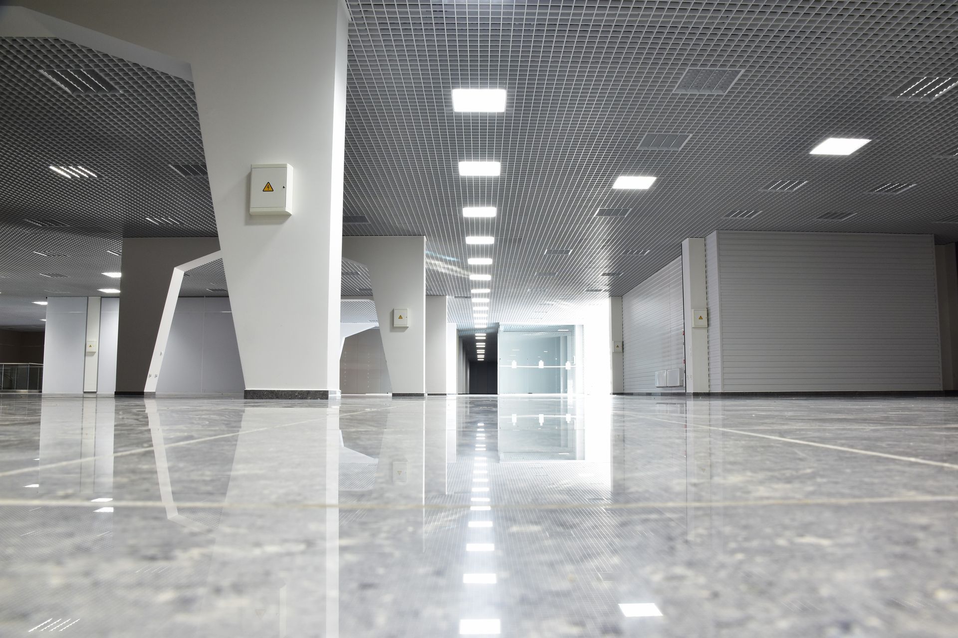 A large empty hallway in a building with a shiny marble floor.