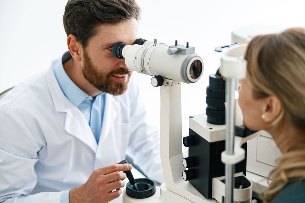 An eye doctor examines a patient's eye with a slit lamp.