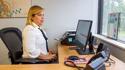 Woman with blonde hair, typing at a desk in an office. Woman with blonde hair, typing at a desk in an office.