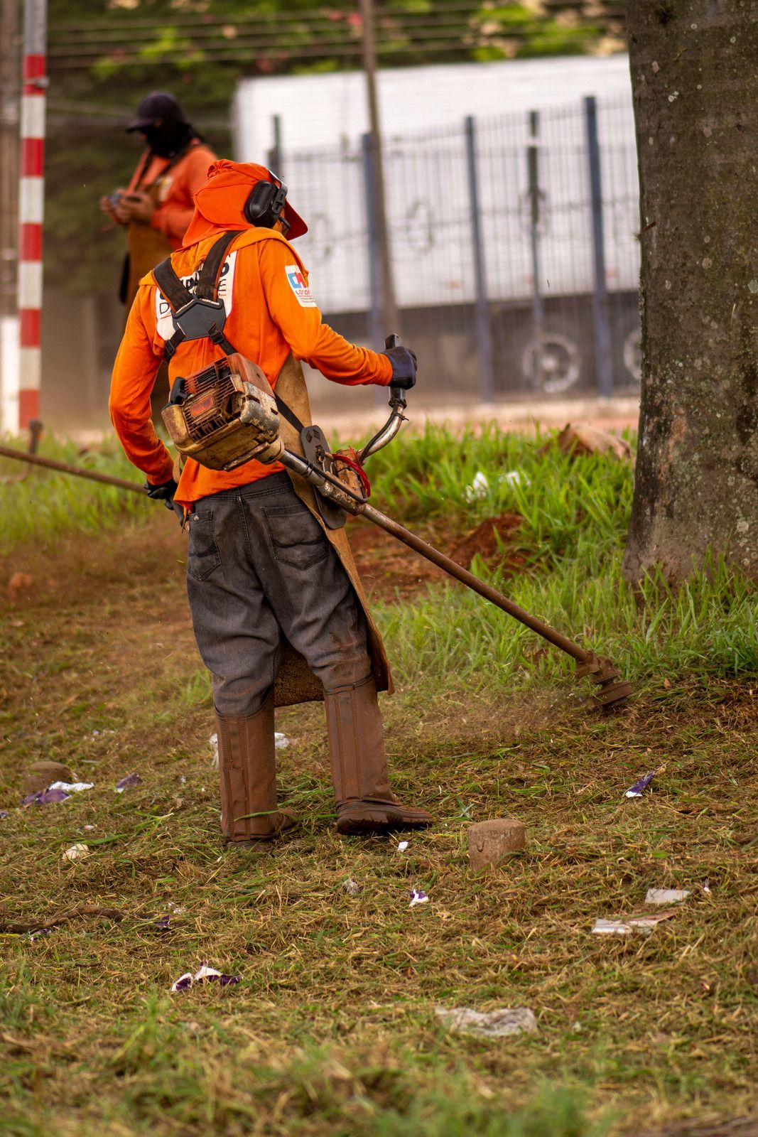 A man is mowing the grass with a lawn mower.