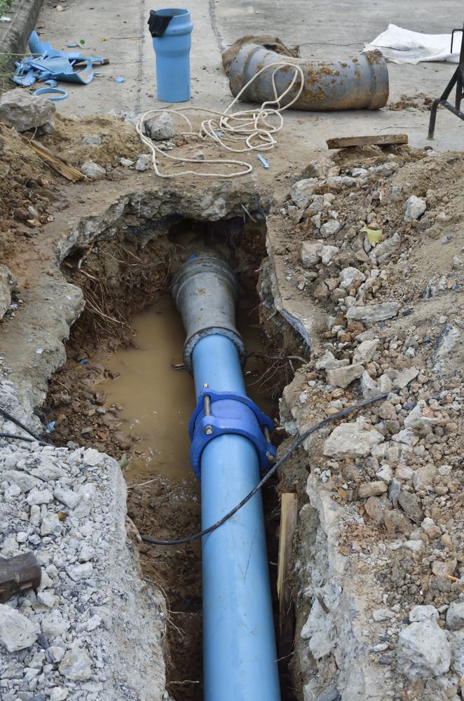 A Blue Pipe Is Being Installed In A Hole In The Ground — Sampson Plumbing Pty Ltd In Kingscliff, NSW