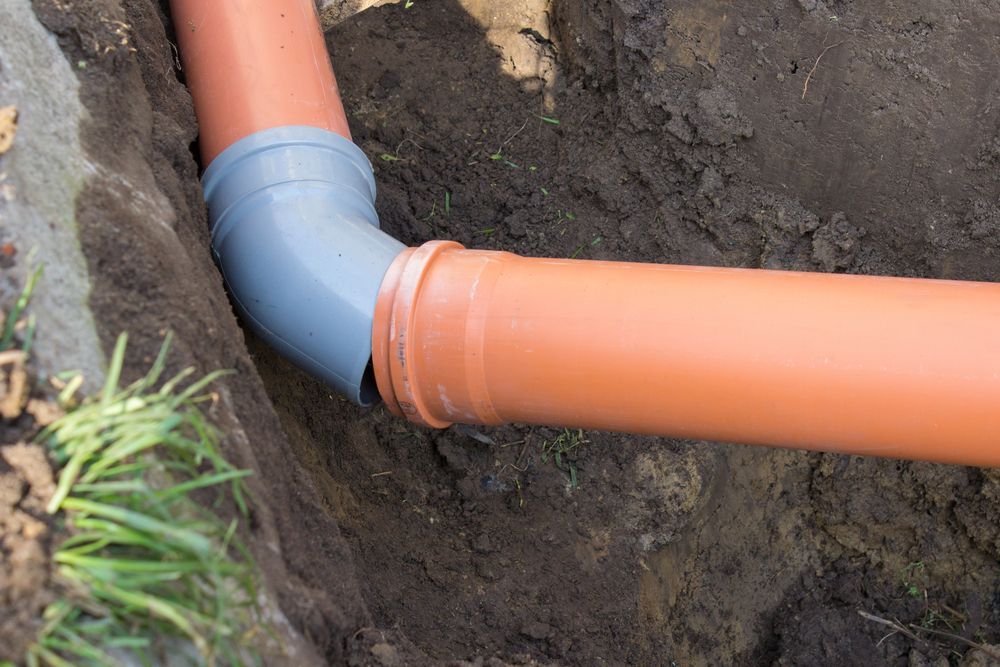 A Couple Of Pipes Are Connected To Each Other In The Dirt — Sampson Plumbing Pty Ltd In Kingscliff, NSW