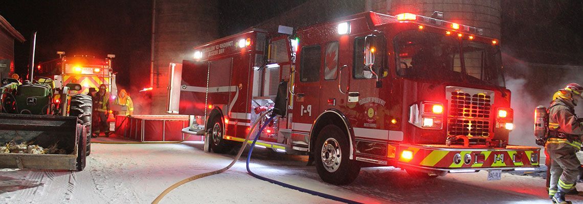A fire truck parked at night, with its lights on.