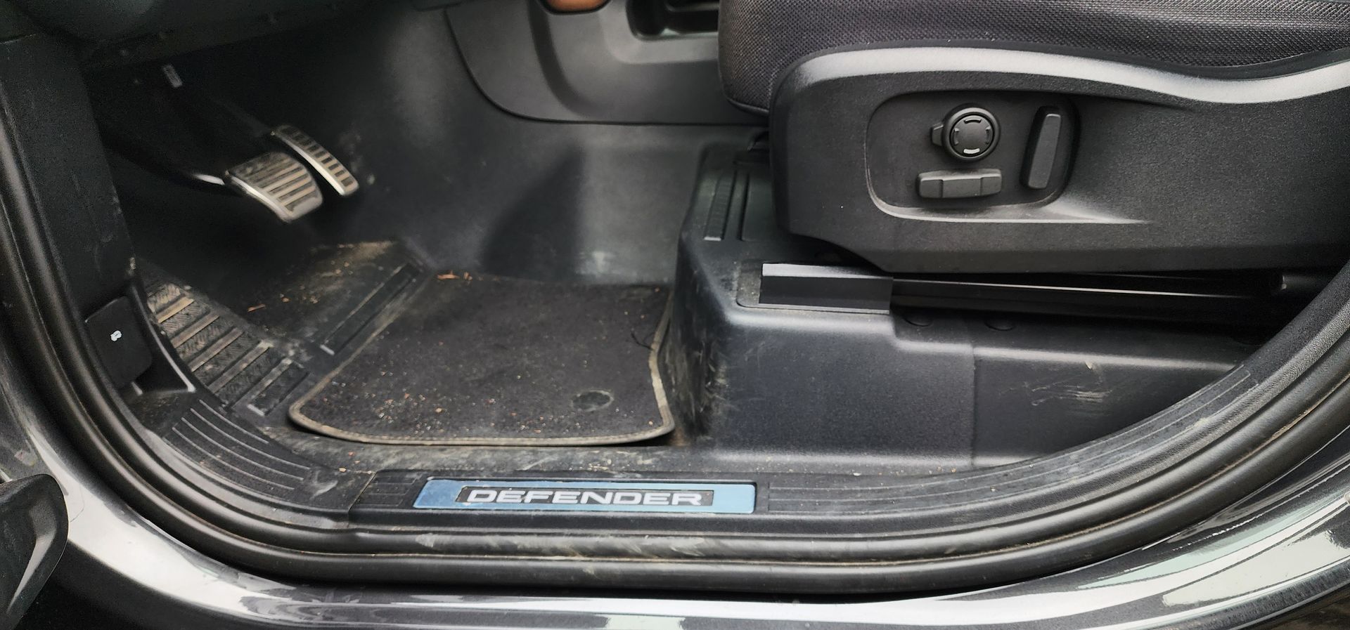 Car floor mat and seat base with scuff plate and driver footwell controls