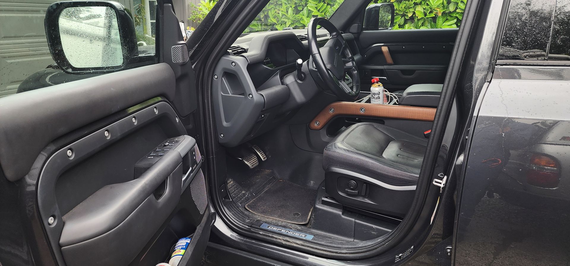 Open car door showing a black interior with seat and dashboard.