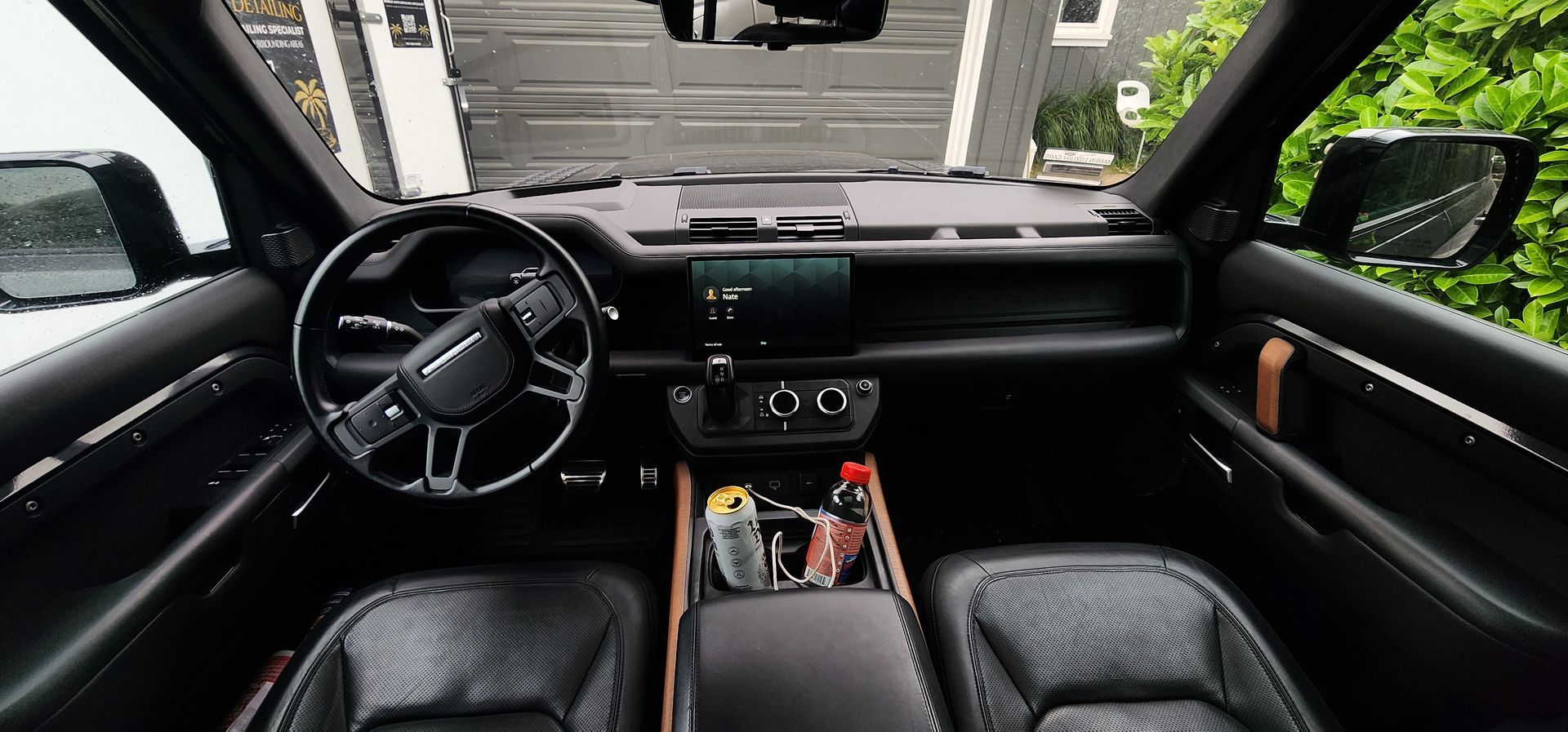 View from driver’s seat of a luxury car interior with black leather seats and dashboard