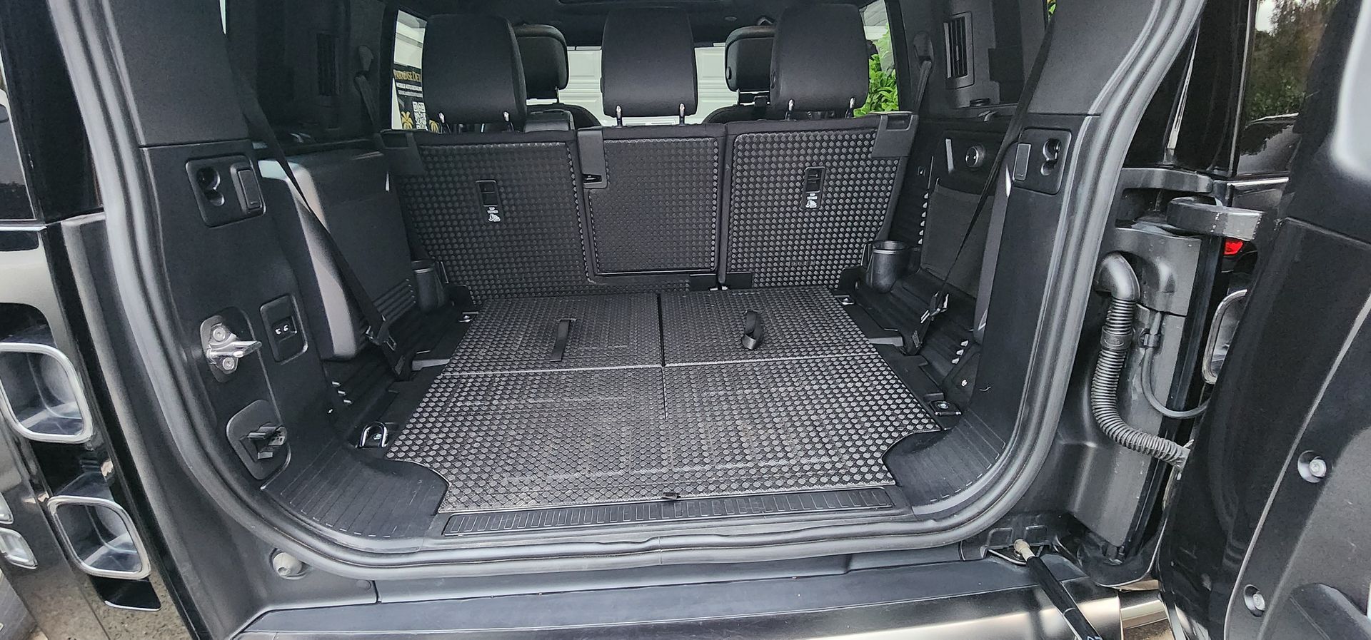 SUV cargo area with folded rear seats and black protective matting inside
