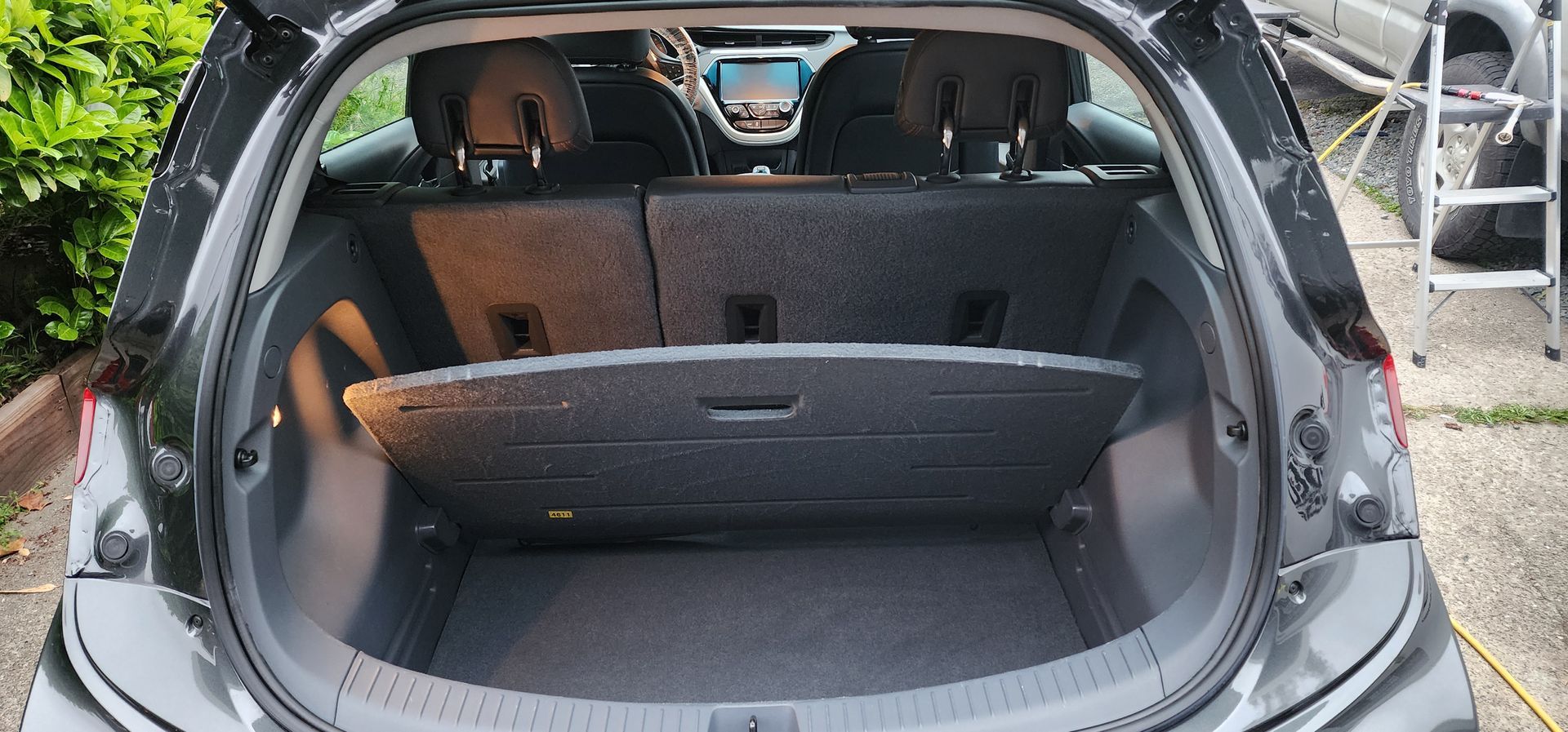 Open car trunk with folded rear seats and brown cargo area visible.