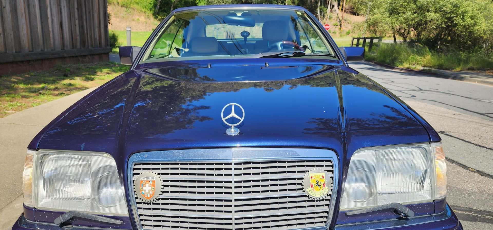 Front view of a blue Mercedes-Benz sedan parked outdoors in daylight