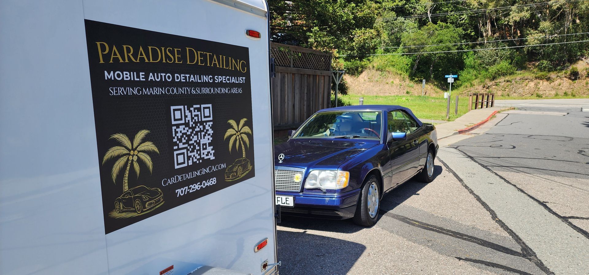White van with Paradise Island sign beside a blue car on a sunny roadside.