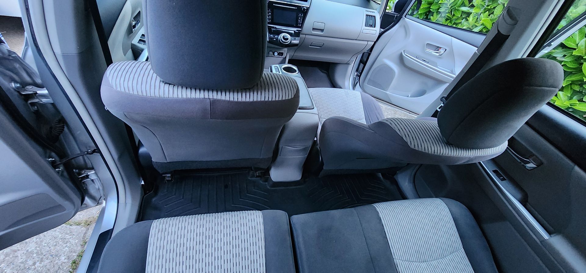 Car interior with gray-and-black seats, viewed from the back seat toward the dashboard and front seats