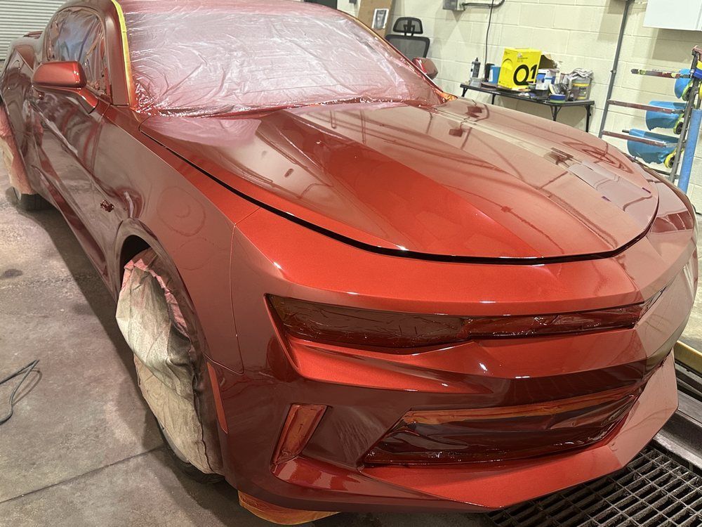 Red Car Being Painted in A Workshop | Peak Customs and Collision Inc