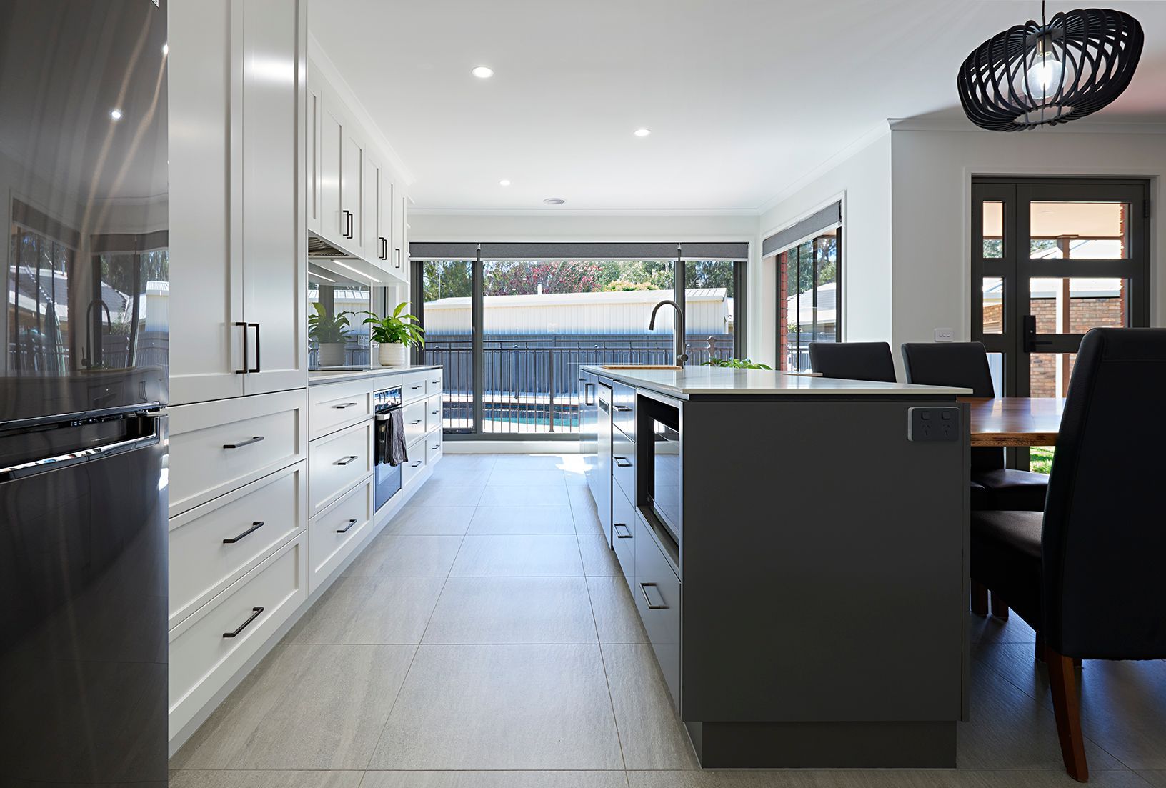 Spacious two-toned kitchen. White cabinetry along cooktop wall, and grey island cabinetry.