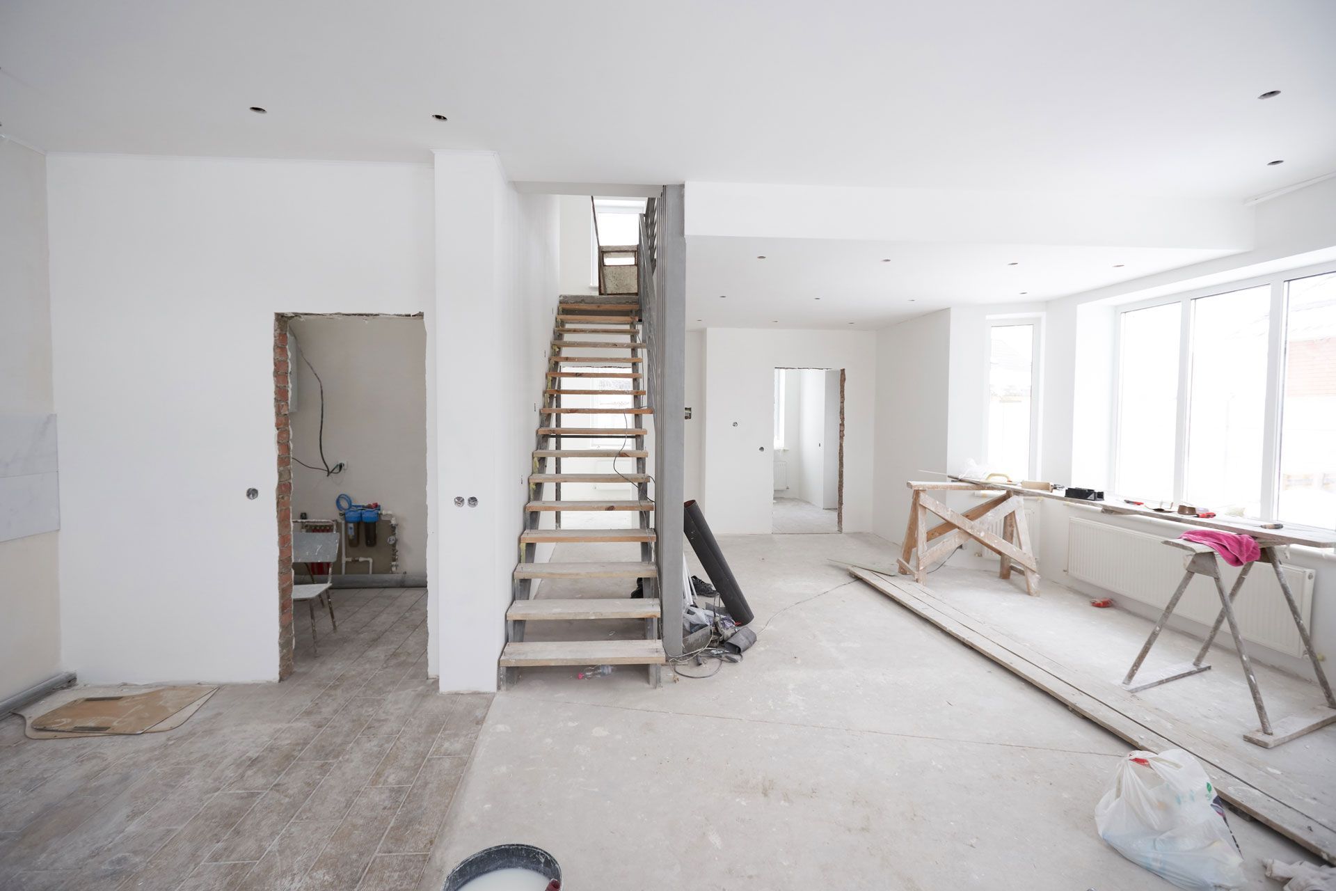 An empty room with a wooden staircase going up to the second floor.