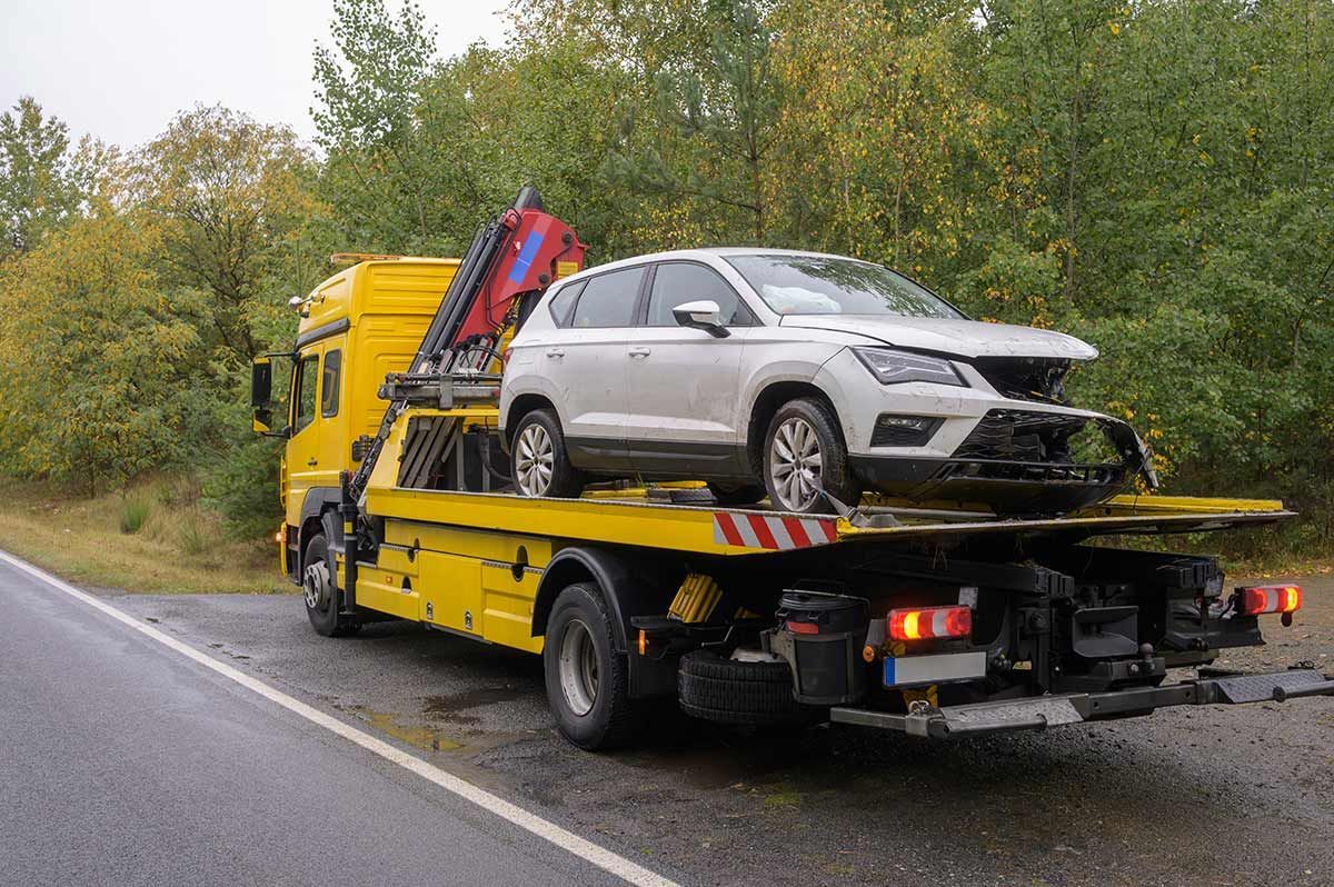 A Car Is Being Towed by A Tow Truck on The Side of The Road — Bakers Creek Wreckers In Bakers Creek, QLD