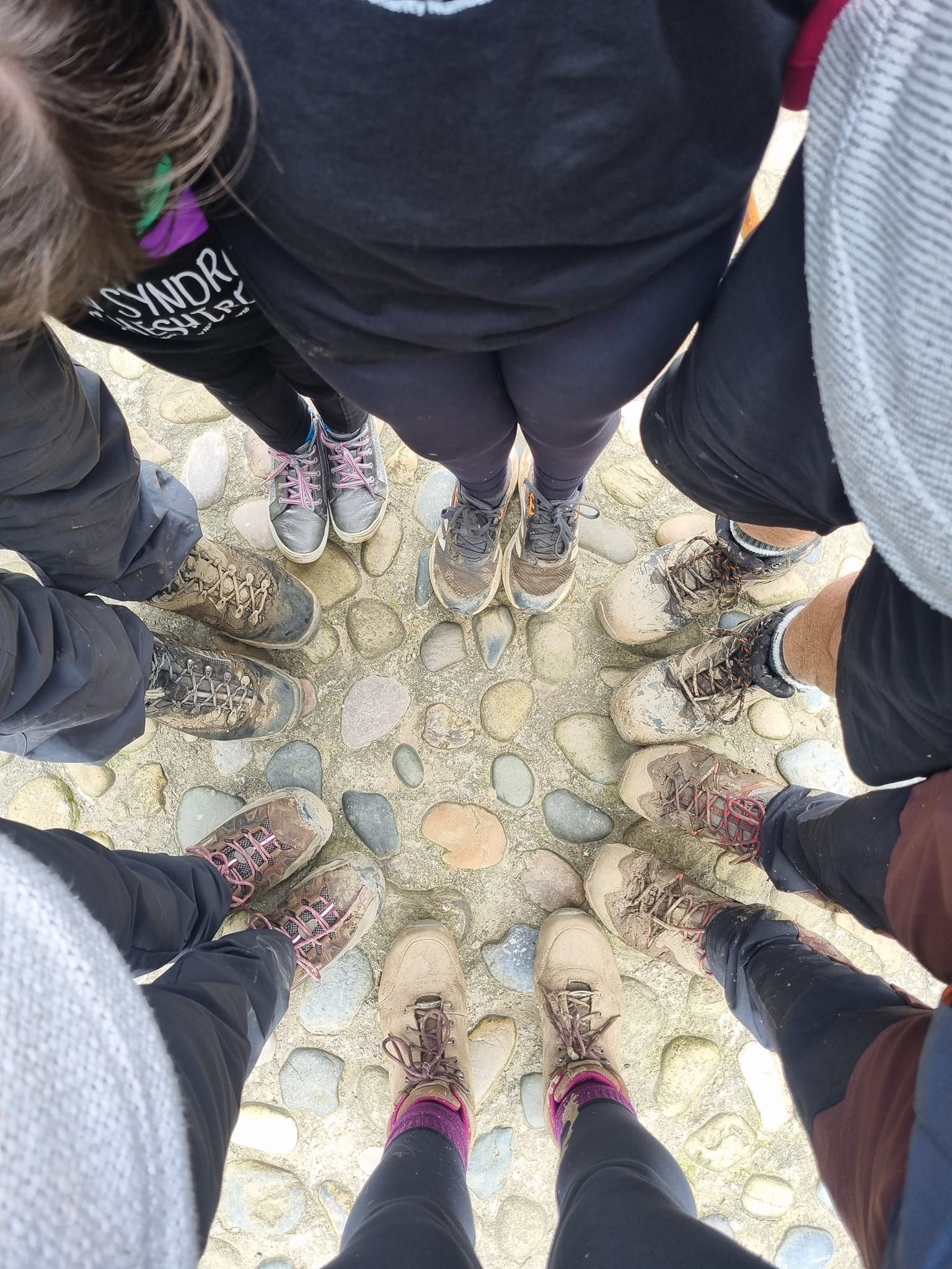 A group of people are standing in a circle on a rocky surface.