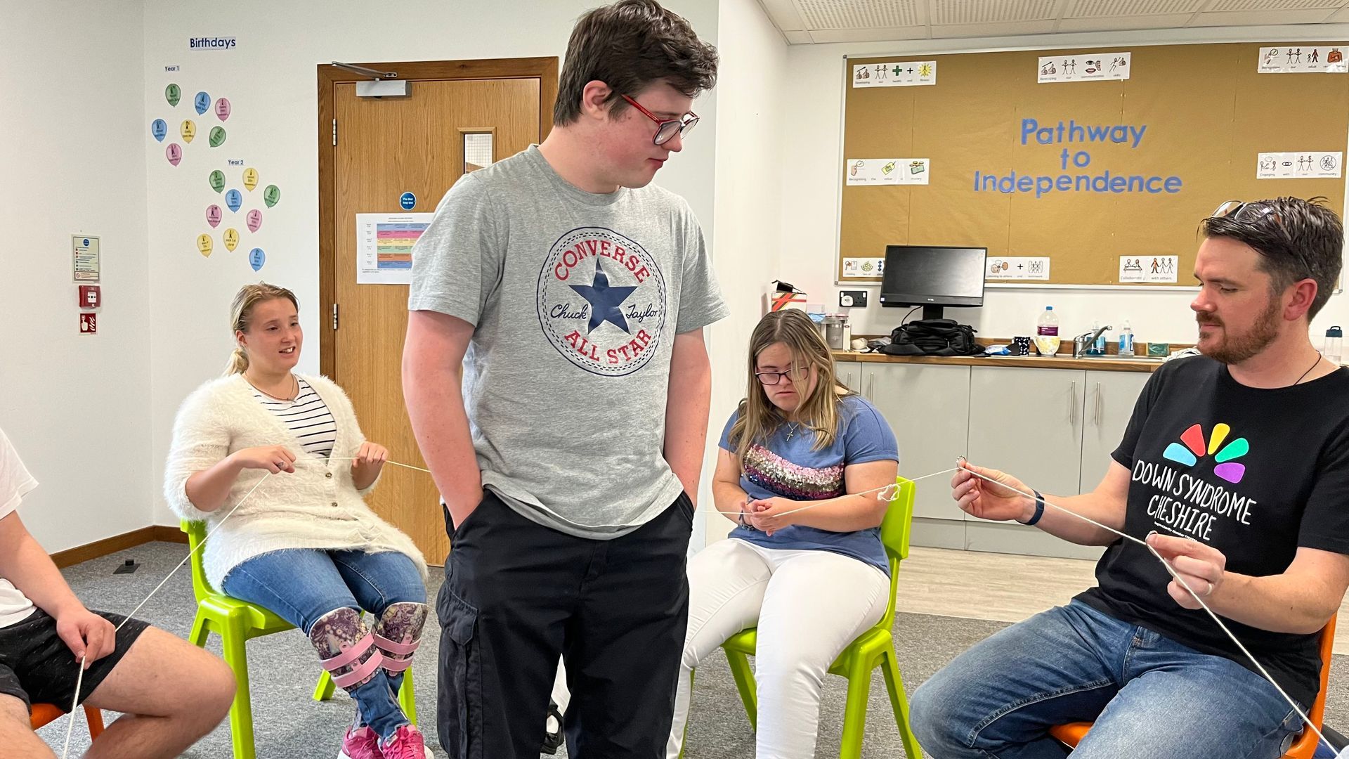 a group of people are sitting in chairs in a room .