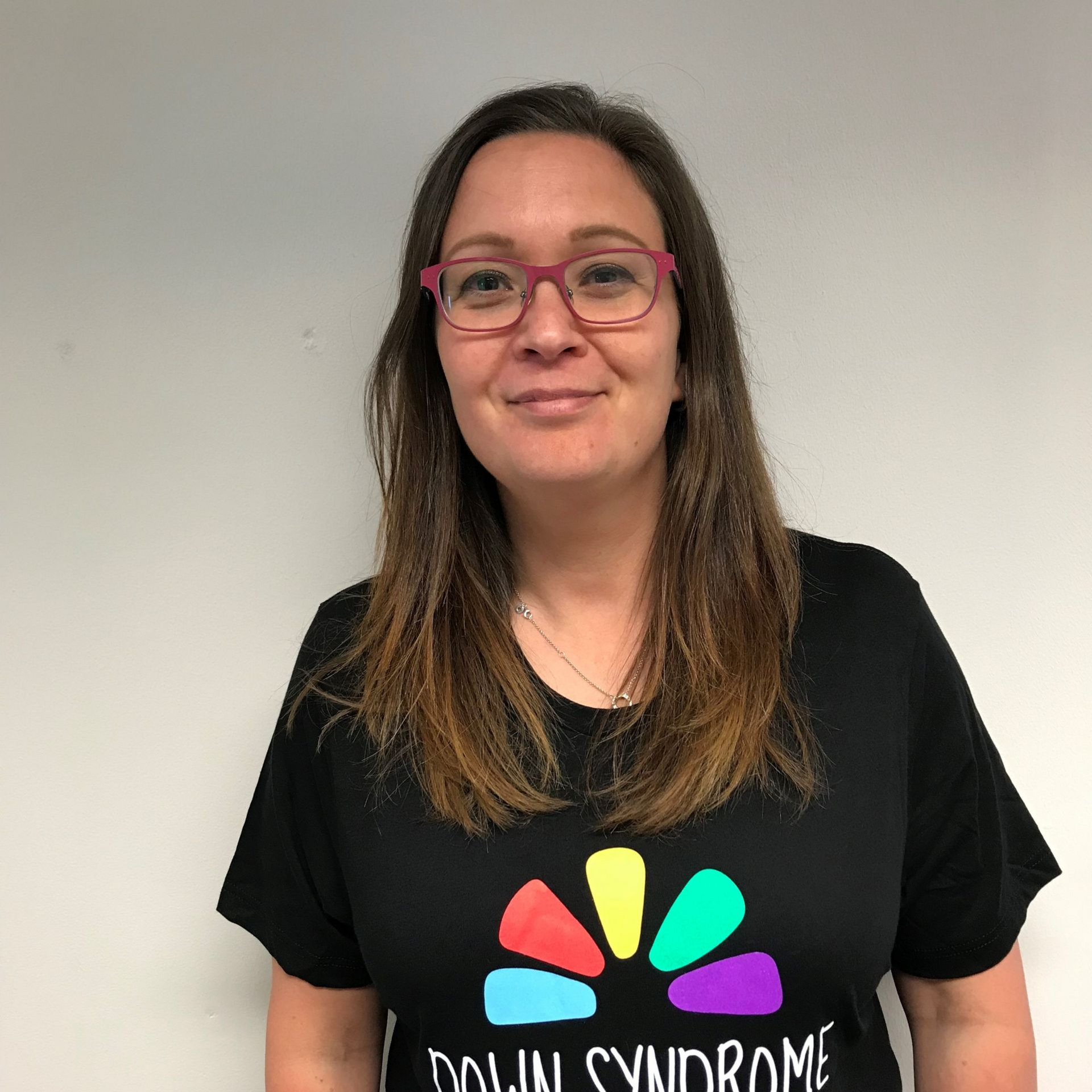 a woman wearing glasses and a black shirt is smiling .