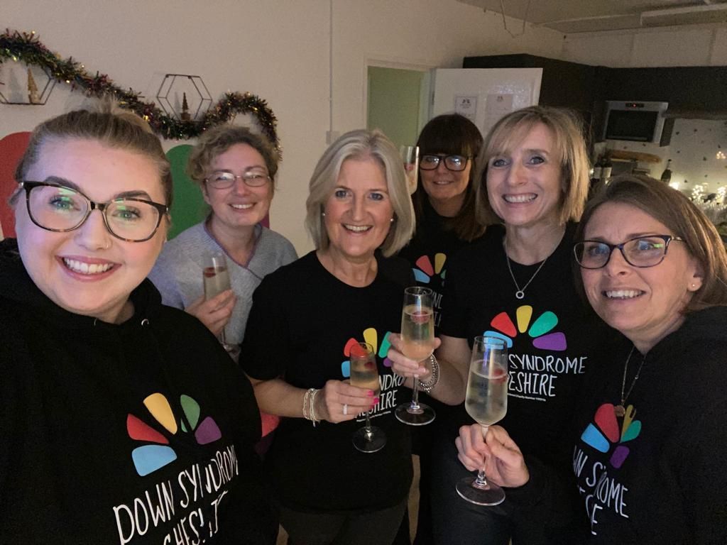 a group of women are standing next to each other holding champagne glasses .