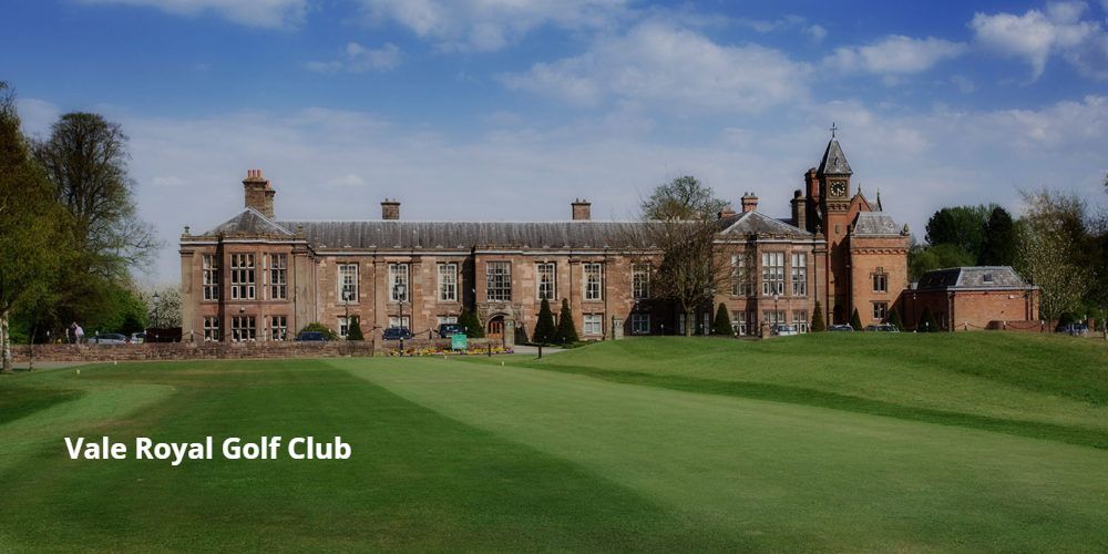 A large brick building is sitting on top of a golf course.