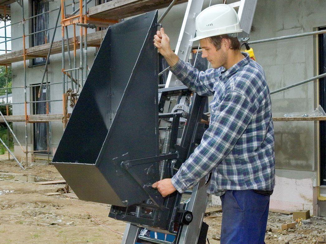 Un homme portant un casque de sécurité travaille sur une machine sur un chantier de construction.