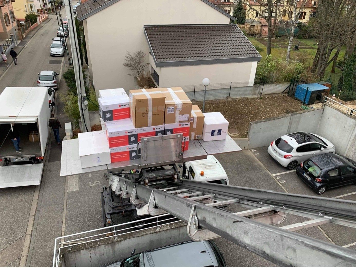 Une vue aérienne d'un camion transportant des cartons sur un parking.