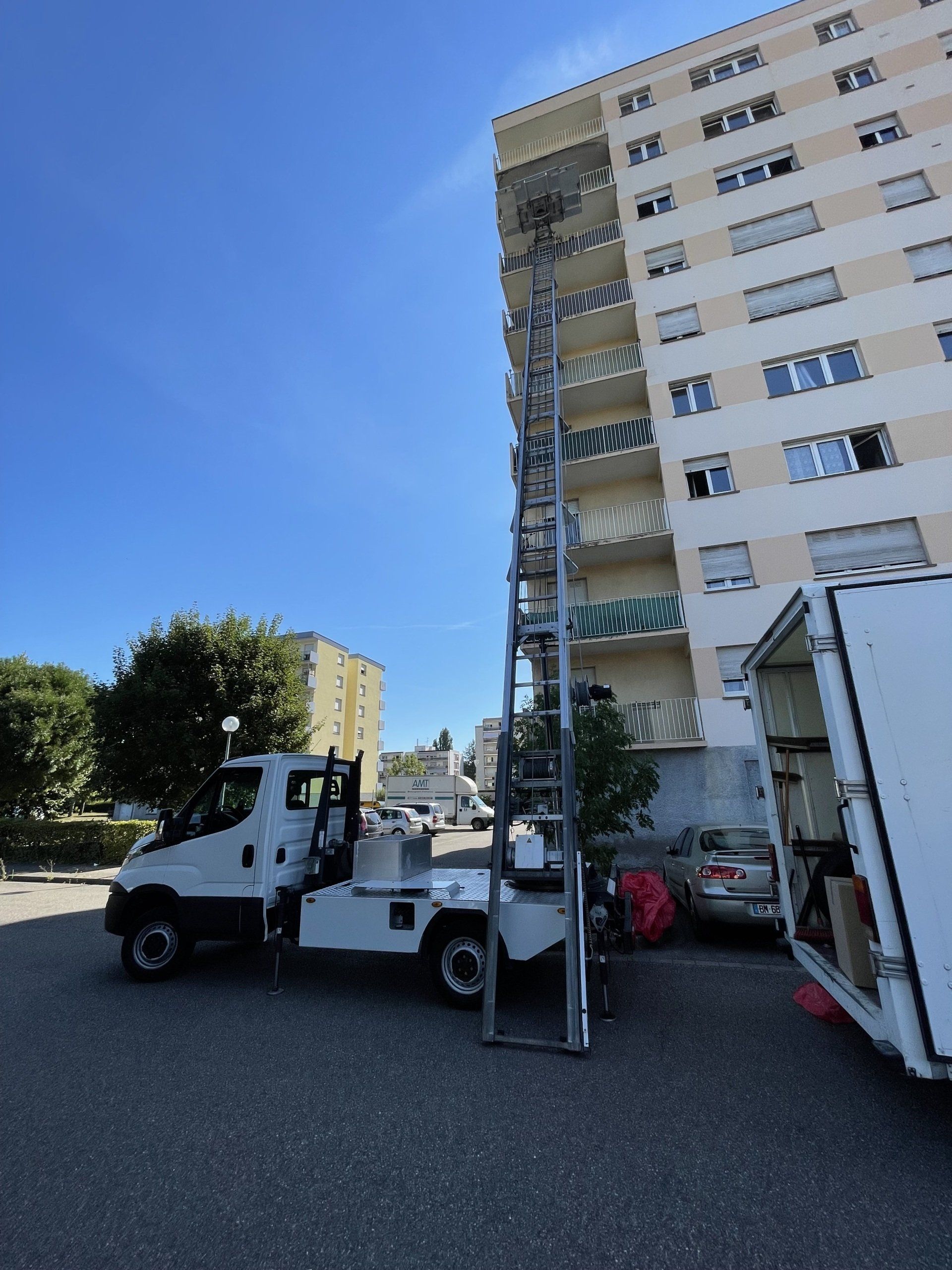 Un camion blanc est garé devant un grand bâtiment