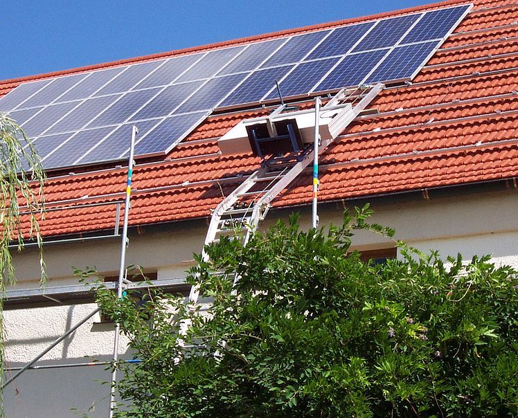 Une échelle est attachée à un toit avec des panneaux solaires