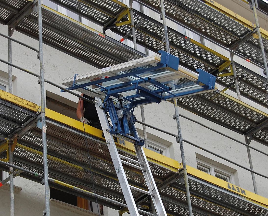 Une échelle est attachée à un échafaudage sur le côté d'un bâtiment.