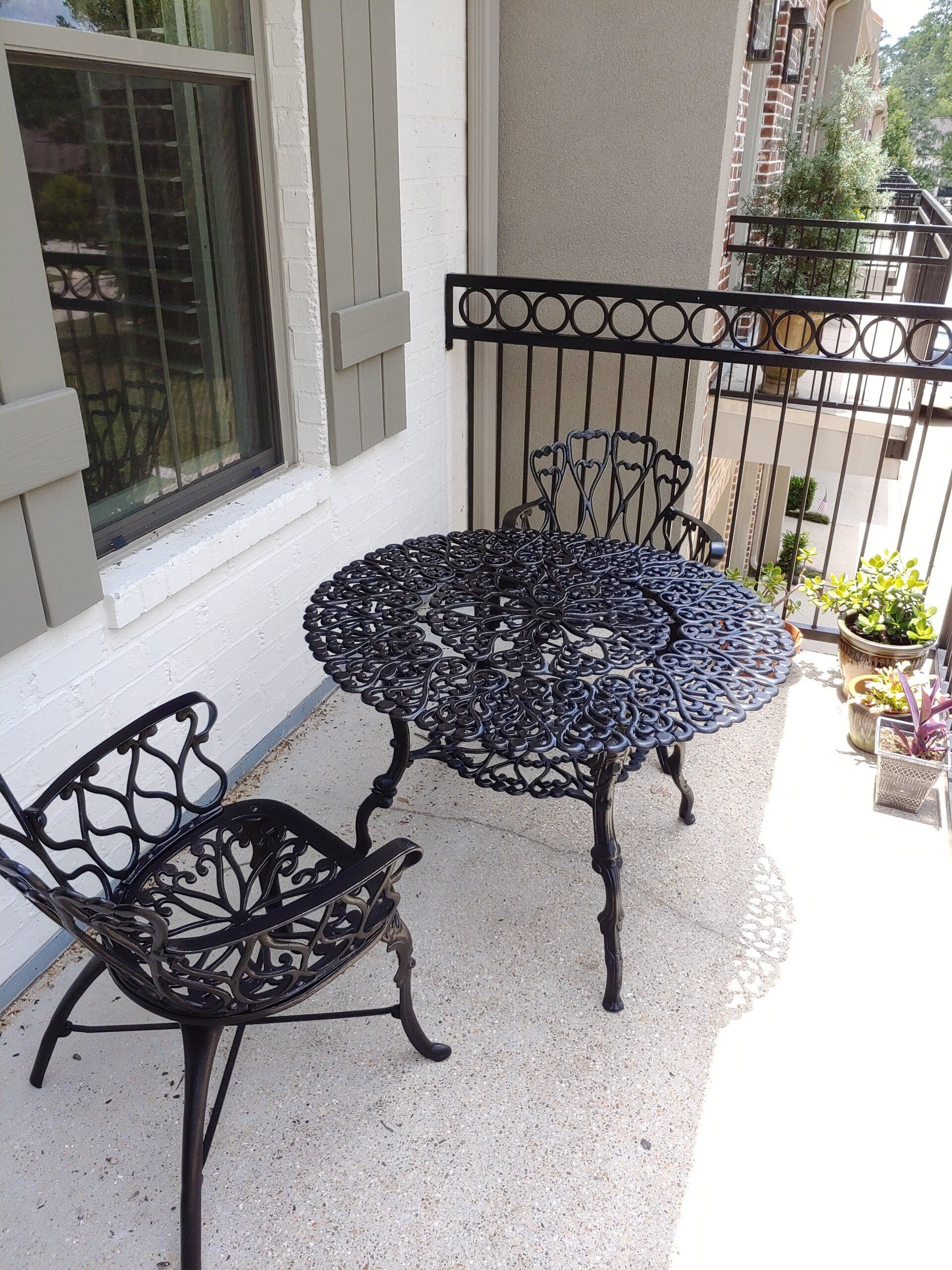 A balcony with a table and chairs in front of a window