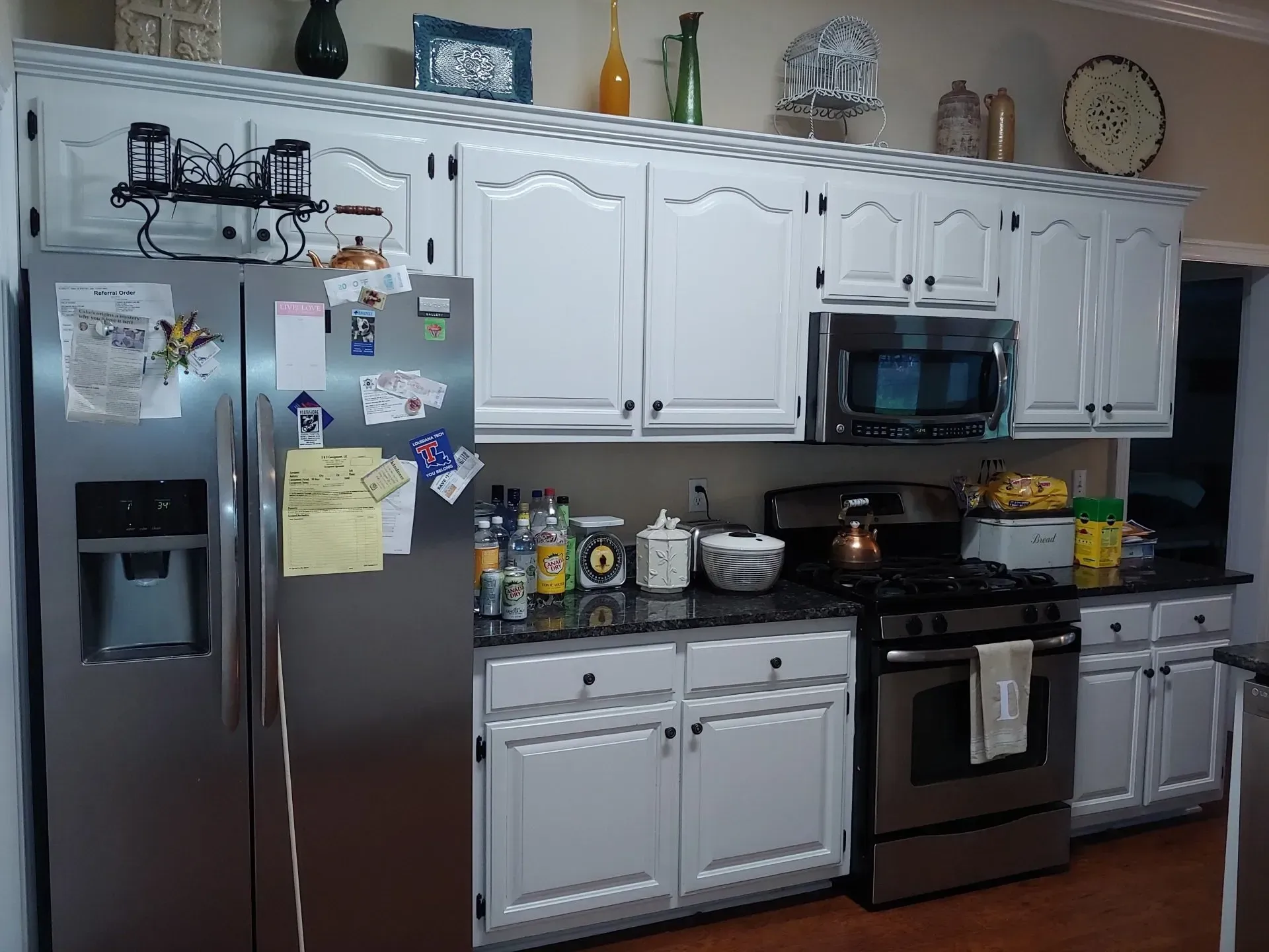 A kitchen with white cabinets and stainless steel appliances