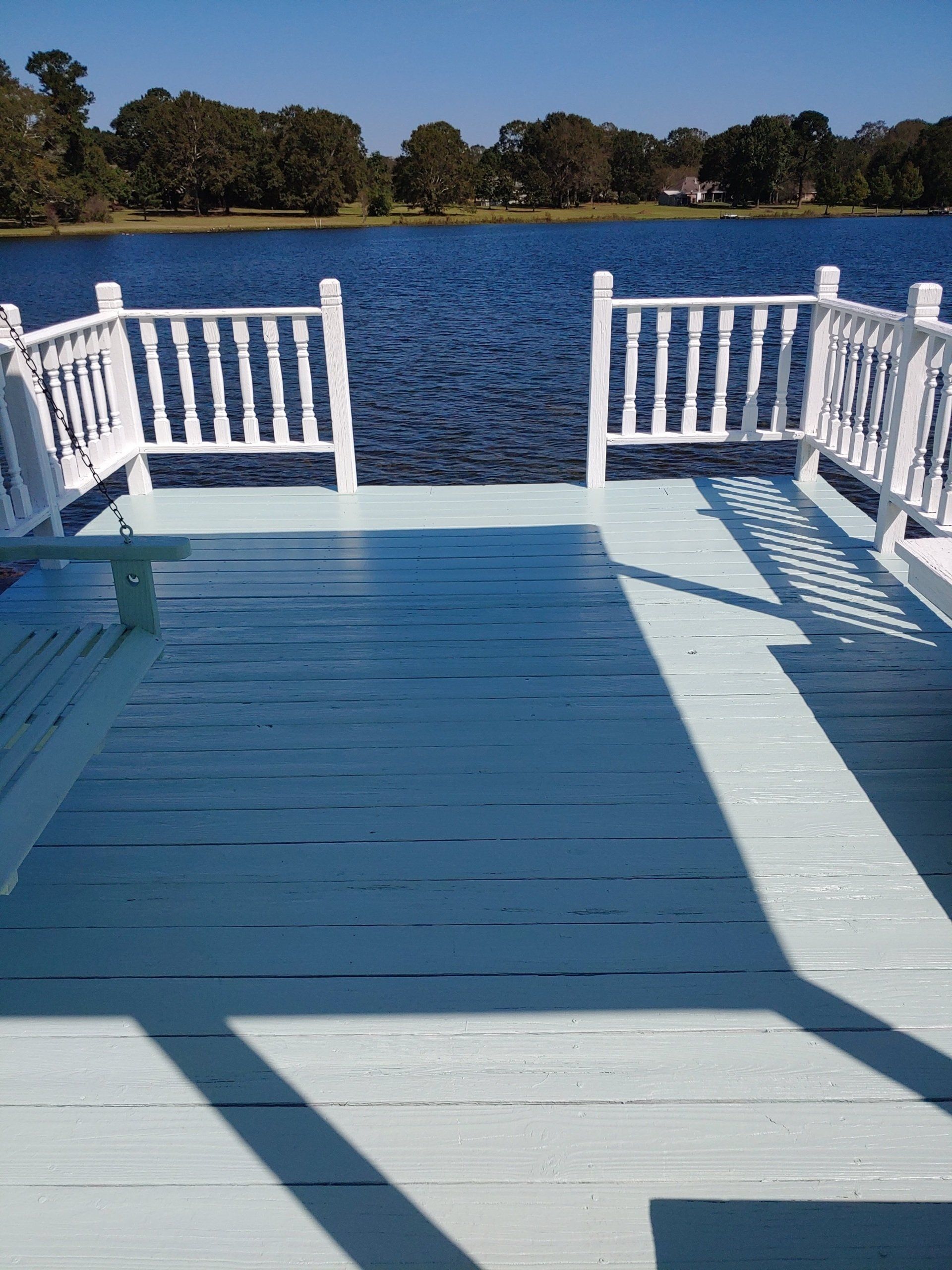 A dock with white railings overlooking a lake