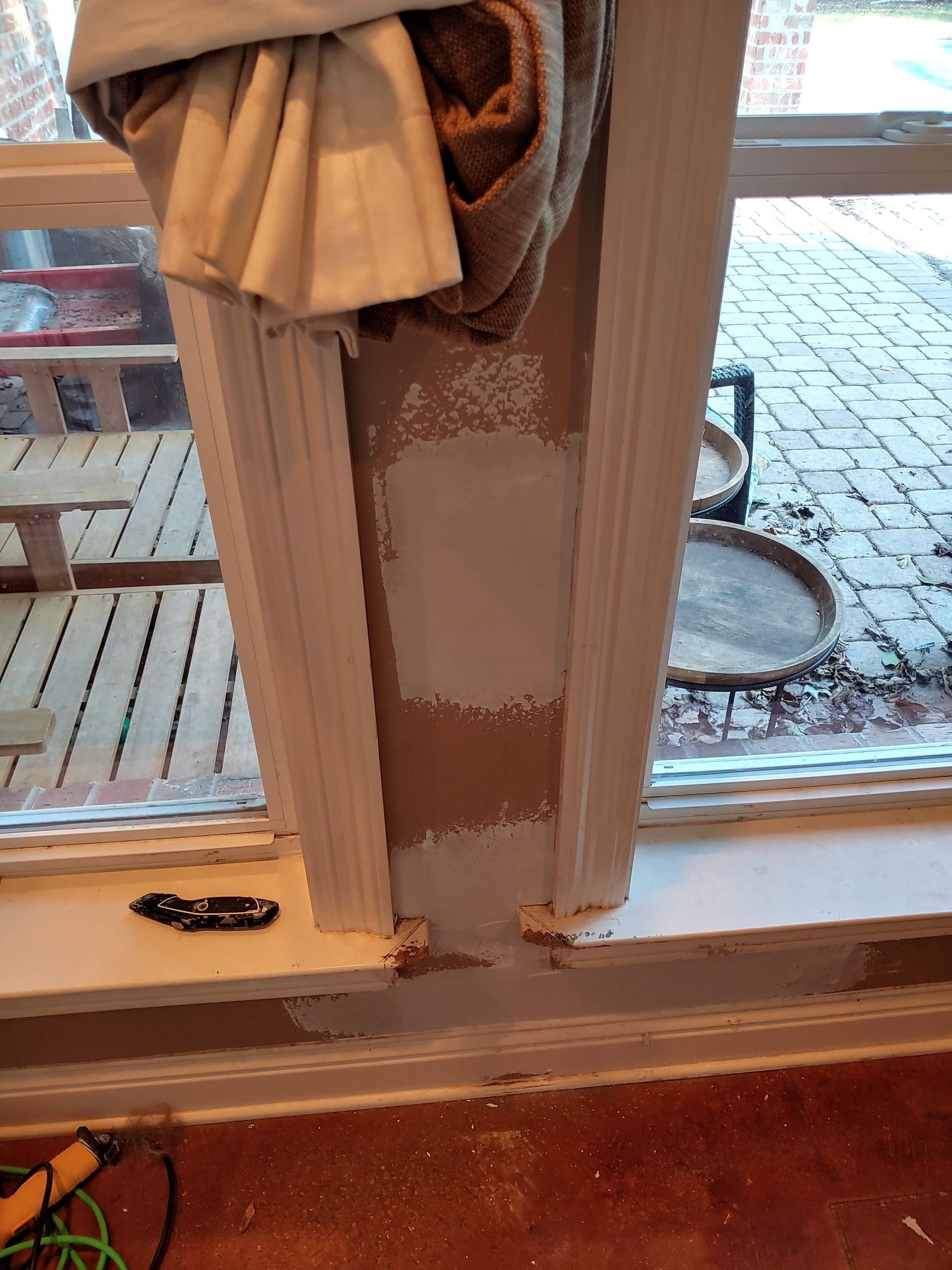 A towel is hanging on a window sill next to a window.