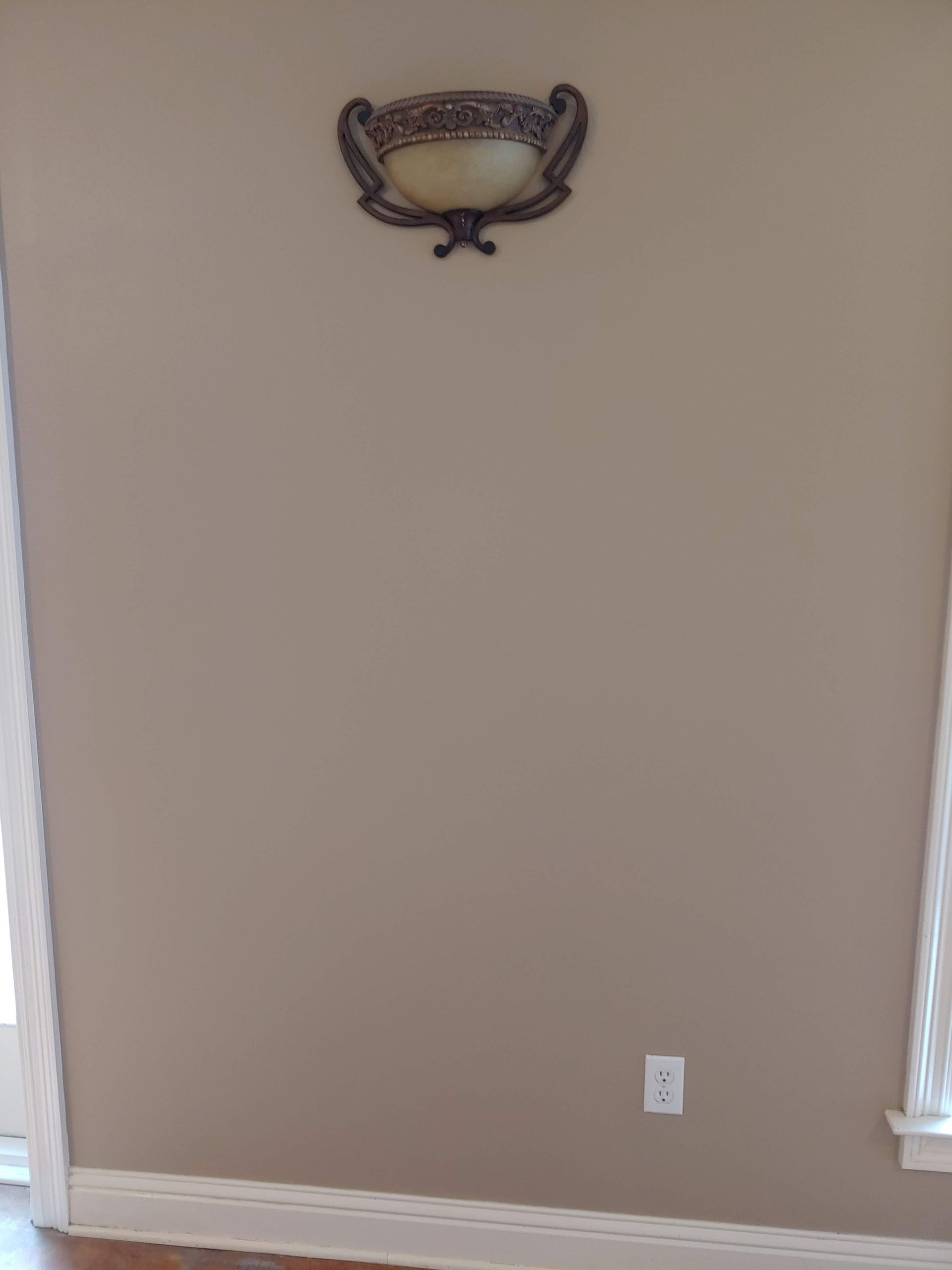A lamp is hanging on a wall next to a window.